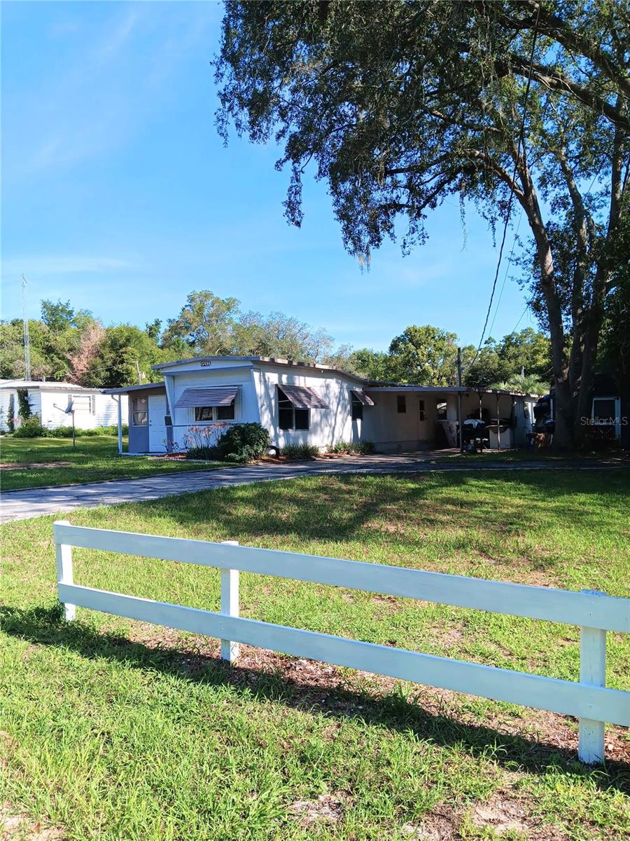 Private property. NO HOA/NO ASSOCIATION. This property is just under 1/4 acre and within 3 blocks to the Villages. Full time living, part time living, short term rental or long term rental options! Full ownership allowing for options. The addition to the single wide allows for a 3 bedroom/2 bathroom living. There is a fenced yard in the back and an hand built wood shed for extra storage. The natural firepit is an additional feature on the side of the house. Quiet neighborhood although just minutes to shopping. Excellent location, home will need some care which is expected, although in liveable condition. Popular location and private land make this a great combo for the next buyer. Financing is possible. Minimum 20% down.