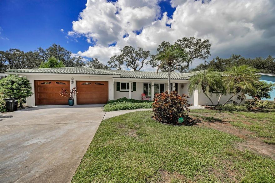 Welcome to Harbor Bluffs, one of Pinellas County’s most coveted subdivisions, where relaxed Florida living meets everyday comfort and family-friendly charm.  Just moments away from the sun-drenched, sugary sand shores that embody Florida’s Coastal charm and Florida living!  This stunning 3-bedroom, 2-bathroom home with thoughtfully designed living space includes a sun-filled Florida / Family room and an elegant, screened retreat with radiant wood flooring overlooking a scenic backyard escape and an oversized 2 car garage, all blending timeless charm with a modern feel and thoughtful upgrades. This beautifully maintained, Mid-Century modern, Rock-Solid residence with a Barrel Tile Roof, Saltillo tile flooring with sun-baked hues and generous sized bedrooms is designed for easy living and effortless entertaining, with spacious interiors and inviting outdoor spaces that make everyone feel right at home. High and Dry, with No Flood Insurance required, the property remained untouched by recent storm events, offering peace of mind and year-round enjoyment.  Inside, natural light fills the bright and airy layout, featuring a timeless split floorplan ideal for families who value both connection and privacy. Enjoy an Efficient galley-style kitchen seamlessly connected to the dining area, sophisticated main bedroom sanctuary with abundant closet space and a beautifully renovated ensuite bath and an expansive living space with electric fireplace designed for both refined entertaining and relaxed daily living. Recent updates—including new windows and doors, New HVAC, Natural Gas throughout, Tankless Water Heater, newer Plumbing and much more! You can move in and start making memories right away! Located in the beloved Harbor Bluffs community, you’ll enjoy mature, tree-lined streets, a private neighborhood park, and quick access to top-rated beaches, shopping, dining, fishing, and nearby cities like Tampa, St. Pete, and Clearwater.  This is more than a house, it’s a place to grow, gather, and enjoy the best of Florida living.