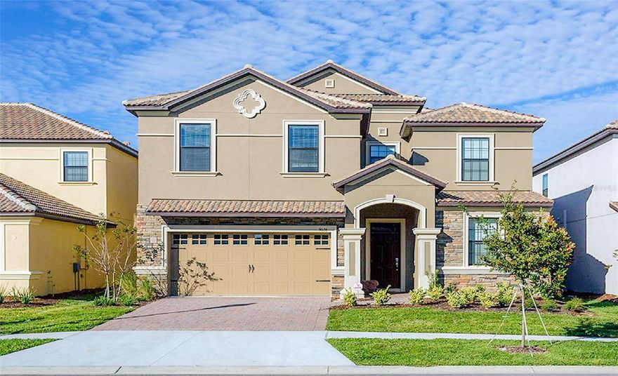 Priced to sell! Exceptional 8-bedroom, 5-bath vacation home just a short walk to the Oasis Clubhouse and its world-class amenities. Combining an unbeatable location, stylish design, and proven rental performance, this property is a standout investment opportunity.

Featuring attractive curb appeal with a stone façade and tile roof, the home welcomes you into a bright, open interior designed for comfort and entertaining. All carpet has been upgraded to luxury vinyl plank flooring throughout, offering a modern look with durability ideal for a high-traffic vacation home. The gourmet kitchen is equipped with granite countertops, stainless steel appliances, upgraded cabinetry, and a large breakfast bar with seating for four. Multiple living spaces across both levels provide plenty of room for guests to gather and relax.

The well-designed floor plan includes a first-floor primary suite and an additional ensuite bedroom downstairs. Upstairs, the media room has been transformed into a private home theater, creating the perfect space for movie nights and added guest enjoyment. Step outside to a covered lanai and a screen-enclosed, west-facing pool and spa—perfect for enjoying Florida sunshine and relaxing in the evenings. 

Don’t miss this rare opportunity—homes this close to the clubhouse, beautifully furnished and truly turn-key, do not last long!