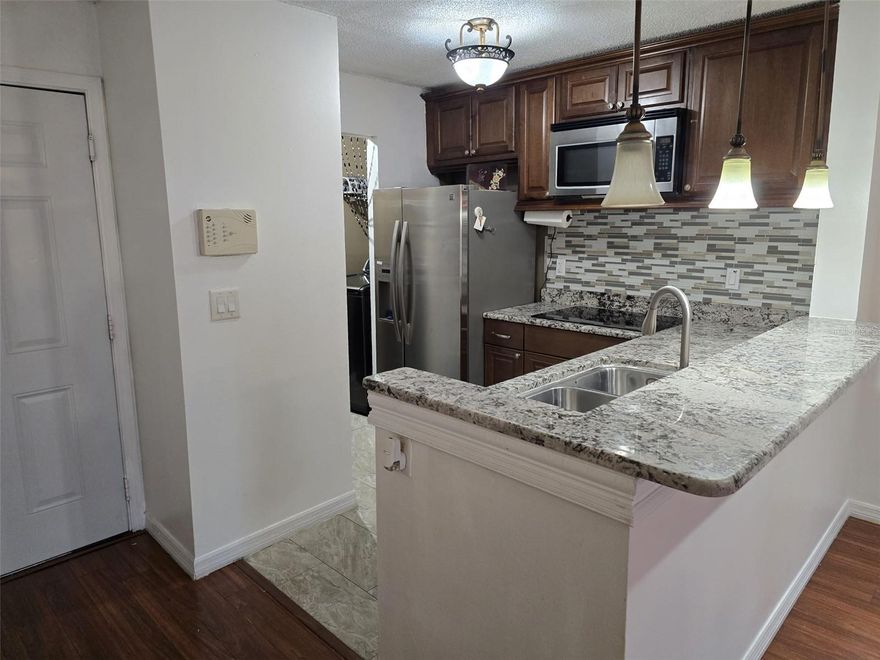 Located in the desirable Carrollwood area, this well-priced 2-bedroom, 2-bath condo offers comfort, convenience, and great value. A brand-new A/C system installed in 2025 provides efficient, worry-free climate control. The interior has been freshly painted and features a bright, open layout that flows seamlessly to a screened balcony. The entry opens to an updated kitchen equipped with granite countertops, stainless steel appliances, an induction cooktop, pantry storage, and an adjacent laundry room with Samsung energy-efficient washer and dryer. The kitchen overlooks a spacious combined living and dining area, ideal for everyday living and entertaining. The split bedroom floor plan offers privacy, with two generously sized bedrooms, both featuring walk-in closets. The primary bedroom includes an ensuite bath, while the second bathroom is conveniently located near the guest bedroom and entry. Both bathrooms have been recently refreshed with new flooring and refinished tub and shower surfaces. Sliding glass doors lead to a newly screened and painted lanai with additional exterior storage, overlooking one of the community’s tranquil fountain ponds and mature landscaping—perfect for relaxing mornings or evenings. This gated community offers a wide range of amenities, including concierge trash service, a resort-style pool, fitness center, clubhouse, tennis courts, sand volleyball court, and dog park. Located on the second floor, the unit enjoys pleasant breezes and elevated views. Its proximity to the main entrance allows quick access to Linebaugh Avenue. Carrollwood remains one of Tampa’s most sought-after areas, known for limited inventory and easy access to restaurants, shopping, entertainment, downtown Tampa, and Tampa International Airport—all within approximately 15 minutes. Plenty of guest and resident parking adds to the convenience. This condo represents an excellent opportunity and is competitively priced—schedule your showing today.