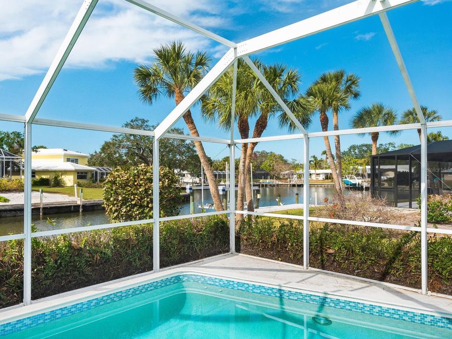 Newly Priced Siesta Key Waterfront —  Blocks to the beach! An inviting opportunity to enjoy relaxed waterfront living on Siesta Key, this well-maintained residence is ideally positioned just minutes from the powdery white sands of world-famous Siesta Beach and the turquoise waters of the Gulf. Set on an oversized 14,000-square-foot corner lot, this four-bedroom, three-bath home blends comfortable coastal living with everyday functionality in a highly desirable island setting. Designed for effortless entertaining and easy living, the open-concept floor plan centers on a spacious island kitchen with generous seating, a breakfast bar, and abundant workspace, flowing seamlessly into the dining and living areas for gatherings both large and small. A thoughtful split-bedroom layout offers privacy for owners and guests alike. The primary suite enjoys peaceful views of the pool and canal, while a secondary bath doubles conveniently as a pool bath—ideal for indoor-outdoor living. Step outside to the covered, screened lanai and unwind beside the sparkling pool, framed by tranquil water views and gentle coastal breezes. Tucked along a quiet harbor just off the Grand Canal, the setting is ideal for kayaking, paddleboarding, or boating, with frequent sightings of manatees and coastal birds adding to the natural charm. Evenings bring glowing “mango sunsets” nearby, while mornings begin with soft sunrises reflected on the water. Additional highlights include an oversized two-car garage and a concrete tile roof. Ideally located near the shops, dining, and energy of Siesta Village—and just 15 minutes from downtown Sarasota’s vibrant arts and cultural scene—this home presents a compelling opportunity to enjoy the best of island living, whether as a full-time residence or a serene coastal retreat.