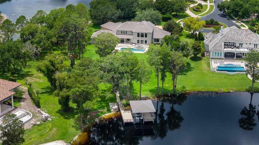 Perfectly positioned on more than 1.3 private acres within the prestigious Northbridge at Lake Pretty, this extraordinary lakefront estate offers refined waterfront living on one of Odessa’s most coveted 90-acre ski lakes.

A stately approach and commanding presence set the tone for this remarkable residence. Inside, the grand rotunda foyer makes a stunning first impression with travertine flooring featuring custom inlays, a sparkling crystal chandelier, soaring ceilings, and a dramatic sweeping circular staircase. Just off the foyer, a private executive office provides a quiet and sophisticated workspace.

Designed to embrace its spectacular setting, the home is filled with breathtaking panoramic lake views showcased through dramatic two-story windows from nearly every room. The magnificent great room serves as the heart of the home, where soaring volume ceilings, clerestory windows, and automated window treatments create an impressive setting for both intimate gatherings and large-scale entertaining.

The gourmet kitchen is thoughtfully designed for culinary enthusiasts and effortless entertaining alike, featuring rich custom cabinetry, granite countertops, upgraded appliances, and an oversized center island with gas cooktop, all complemented by stunning waterfront views. Nearby, the breakfast nook is highlighted by a striking mitered glass window overlooking the resort-style pool, spa, and tranquil lake beyond.

The main level also features a dedicated home theater complete with stadium seating, surround sound, and projection system for an immersive entertainment experience.

The luxurious primary suite serves as a private retreat, offering beautiful wood flooring, elegant double-tray ceilings with crown molding, generous walk-in closets, and serene lake views. The spa-inspired bath is appointed with granite countertops, a walk-in shower, and a relaxing garden Jacuzzi tub.

Upstairs, a spacious loft offers the perfect reading or gathering space, accompanied by a versatile bonus room or fifth bedroom with full-size laundry and two generously sized secondary bedrooms connected by a Jack-and-Jill bath. Throughout the home, solid wood flooring extends seamlessly with no carpet remaining.

Significant recent improvements further enhance the estate, including replacement of all three HVAC systems, a stunning architectural tile roof on both the residence and boathouse, and a freshly completed full exterior paint transformation.

Outdoor living unfolds as a private lakeside sanctuary. The family room opens to an expansive paver terrace featuring a heated pool and spa overlooking the fully fenced grounds that sweep gracefully to the water’s edge.

For boating and watersport enthusiasts, this property delivers an exceptional lifestyle experience. A rare double-sided garage provides convenient access to the private boat ramp, while the covered dock with boat lift offers generous shaded seating and effortless lake access for boating, skiing, fishing, and endless waterfront enjoyment.

Combining timeless architectural elegance, resort-inspired amenities, and the unmatched beauty of Odessa lakefront living, this exceptional estate offers a lifestyle as remarkable as its setting.