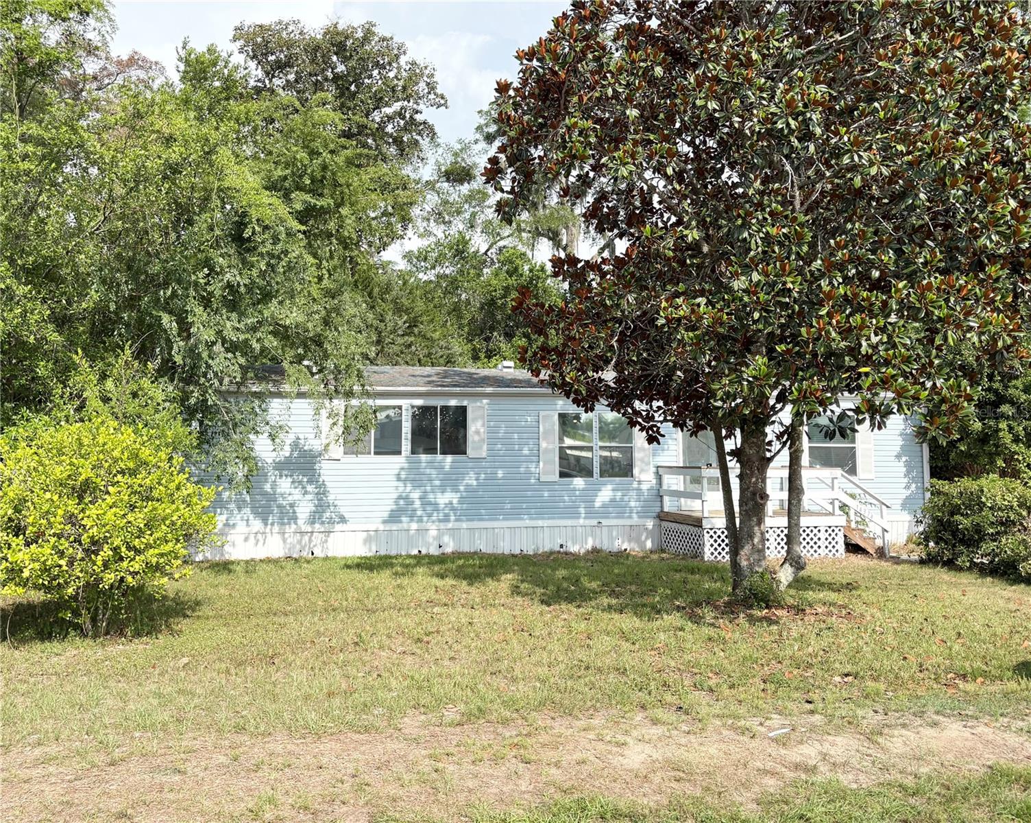 The mature shade trees surround this three bedroom, two bath mobile home. When you walk in the front door you walk into the spacious and open living and dining area, there's lots of cabinet space in the kitchen, new luxury vinyl plank floors throughout, window blinds, a split bedroom plan, an inside laundry room, and for your outdoor enjoyment there is a front and back wood deck. This gem is sitting on more than one quarter acre in Belleview Hills Estates ready for its new buyer. New A/C 2016. Roof 2005.