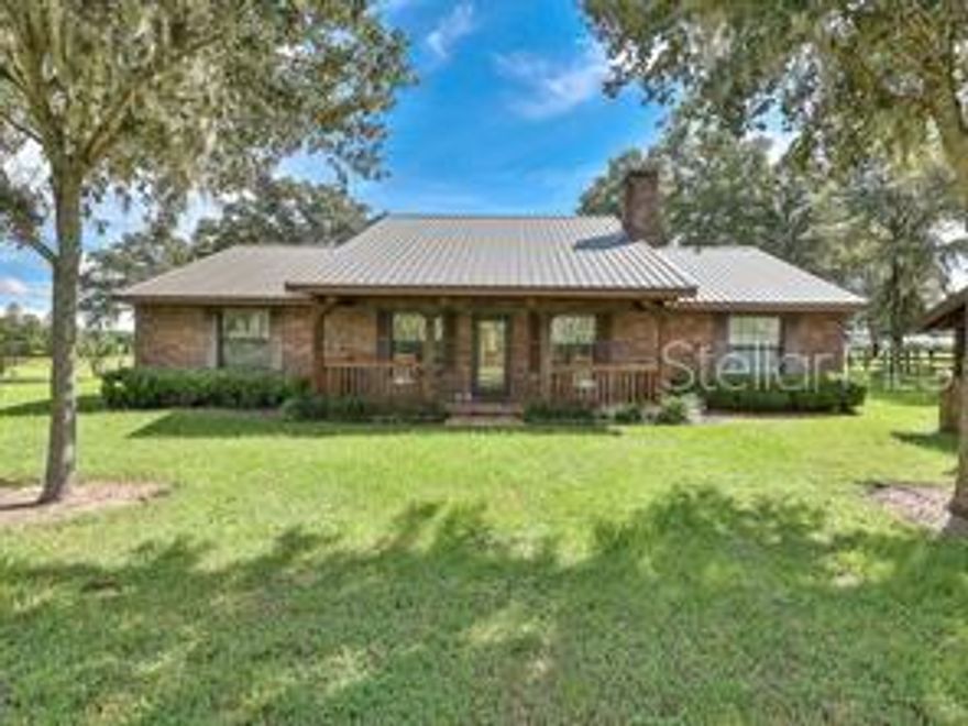 BACK ON THE MARKET!! A SPECIAL PLACE FOR SOMEONE LOOKING FOR A GEM IN THE COUNTRY. This very unique property has just about everything including an immaculate brick home, 2 barns, very nice board fencing for horses or cattle, beautiful live oaks, and a deep water canal stocked with game fish. With a spacious 2,641 total square ft. of living area. The 13 acres has a private, gated entrance that leads to the home as you pass the beautiful live oaks and board fencing. The 3 bedroom 2 bath home has a spacious living room with beautiful hardwood flooring, a brick fireplace, large kitchen with very nice appliances, and a spacious master bedroom with large walk-in closet. This gorgeous ranch home is very energy efficient with a monthly light bill of just over $100. Before approaching the front door, you will enter the front porch, and walk over the nice tile flooring that has been installed over the entire porch. The back porch has been enclosed and converted into a Florida room with tile flooring and many windows overlooking the back patio area and large back yard. When entertaining family or friends, the tiled patio comes with a huge brick barbecue grill and an enclosed fire pit. The property has a 36 x 84 barn that is currently used for parking of vehicles, tractors, and equipment used for maintaining the property. Located near the canal, is a 65 x 65 barn which is used for boat parking and equipment. If you enjoy fishing, the canal has a nice dock for relaxing and catching fish. For the horse lover, the Crescent Lake management area is a short distance from the property with miles of horseback riding trails. Flagler Beach is a short drive away, and for the boating and fishing enthusiast, the historic St. Johns River is a 10 minute drive. The metal roof was installed 3 years ago and the AC has been updated . This picturesque, beautiful property is ideal for the outdoor person and someone who loves nature.