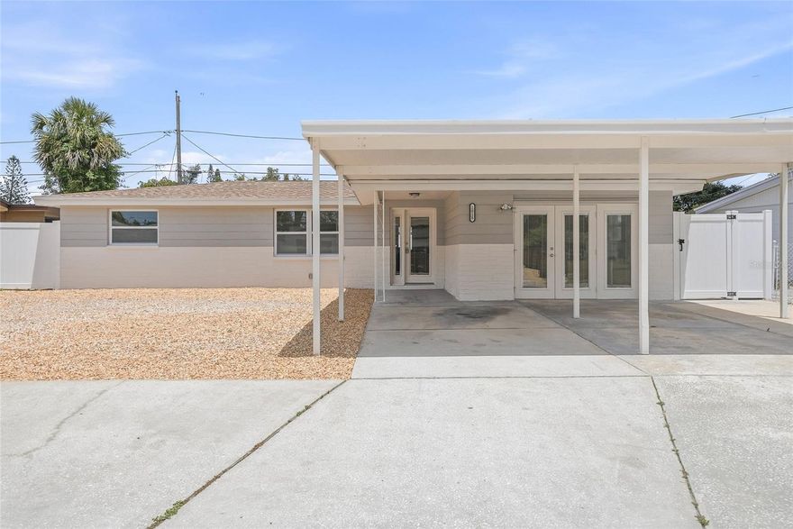 Welcome to this beautifully updated 4-bedroom, 2-bathroom block home offering the perfect blend of modern style, comfort, and functionality. From the moment you arrive, the inviting covered front entryway creates warm curb appeal, while the bright and airy interior immediately makes the home feel open and welcoming. Inside, you’ll find a thoughtfully designed split floor plan with stylish updates throughout, including brand-new windows and wood-look tile flooring flowing seamlessly throughout the home, creating a clean, modern, and cohesive feel. Originally a 2-bedroom, 1-bathroom home, the property was thoughtfully expanded into a spacious 4-bedroom, 2-bathroom layout with all additions and improvements completed with permits and inspections for added peace of mind. The kitchen is a true standout, featuring crisp white shaker cabinetry, sleek quartz countertops, and brand-new appliances that make both everyday living and entertaining feel effortless. Both bathrooms have been fully renovated with clean, modern finishes, creating spa-like spaces that feel fresh and elevated. The spacious primary bedroom offers a unique touch with French doors leading directly outside, adding character and flexibility to the space. Major upgrades provide exceptional peace of mind, including a brand-new HVAC system with upgraded ductwork, a new roof, a new water heater, upgraded 200-amp electrical main service, all new electrical wiring throughout the home, and updated plumbing throughout. Outside, the fully vinyl-fenced backyard offers privacy and plenty of room to relax, entertain, or create your dream outdoor oasis. The oversized 2-car carport adds convenience and functionality, while the solid block construction offers durability and classic Florida living appeal. Perfectly located just minutes from US-19 with endless dining, shopping, and everyday conveniences nearby, this home is also close to the famous Tarpon Springs Sponge Docks, beautiful waterfront scenery, and the trails and nature views of Anclote River Park, giving you the best of both convenience and coastal charm.