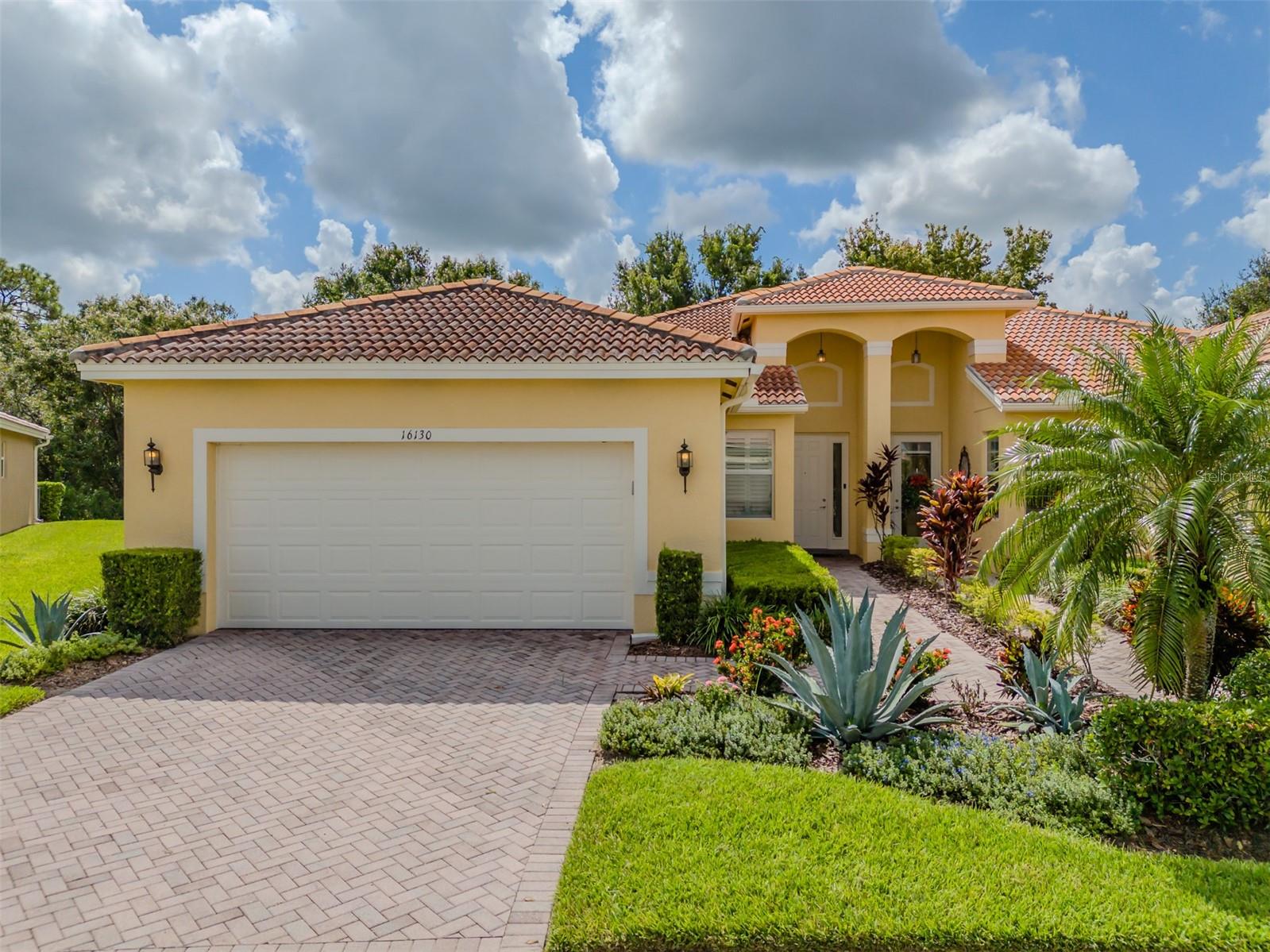 Are you ready for ISABELLA? This GL Homes built ISABELLA villa is calling your name, but can you hear her? With almost 1500SF of delightful living space, that affords two bedrooms, two bathrooms, a dining room, great room, kitchen with dinette, and a truly private lanai, this ISABELLA is guaranteed to meet and exceed your needs and desires. A pavered driveway and walkway and the manicured gardens lead to a towering front portico that welcomes family and friends. Beautiful laminate floors are the foundation of a warm inviting environment that is adorned with elegance throughout. Beyond the foyer is an open floorplan that features an expansive great room that overlooks the gorgeous dining room with its custom millwork and built-in shelving, and a kitchen that will please the most discerning Chef. The 17’x15 great room features a subtly elegant chandelier, two recessed canister lights above the seating area, double French doors leading to the lanai and a commanding view of the open floorplan. The kitchen features white colored solid maple cabinetry with under and over upper cabinet lighting, an abundance of granite counters, a diagonal stone backsplash, and an adjoining casual dining area that will be the perfect space to enjoy daily or intimate meals. Maximizing the use of space, a washer and dryer are practically tucked into the dinette’s closet. The primary bedroom features a lighted ceiling fan, plantation shutters, a feature wall with wainscot and millwork, a triple corbel upper shelf, a large walk-in closet, and a delightful ensuite bathroom. It’s a glorious space to enjoy your daily retreat. The second bedroom is at the front of the villa and features a lighted ceiling fan, plantation shutters and an adjoining bathroom. It will ensure that your guests have comfort and privacy. The lanai provides a tranquil space to appreciate nature’s beauty. Environmental comforts are delivered by Carrier 3.5-ton HVAC, a Culligan whole-house water softener system and a whole house audio system. This ISABELLA is certain to please you in every way. Located in Valencia Lakes, Tampa Bay’s premier 55+ Active Adult community, which has an amazing 40,000 sq ft clubhouse offering entertainment shows, dances, myriad clubs, a state-of-the art 24/7 Fitness Center, resort-style pool, lap pool, exercise classes, card rooms, pickleball, tennis and much more. Conveniently located near two new hospitals and the brand new MOFFIT Cancer Center, Downtown Tampa, Tampa airport, and a short drive to Disney, Cruise Ports, Sarasota and some of the best beaches in the country! Come enjoy elegant comfort and live out your idyllic life in this special home.