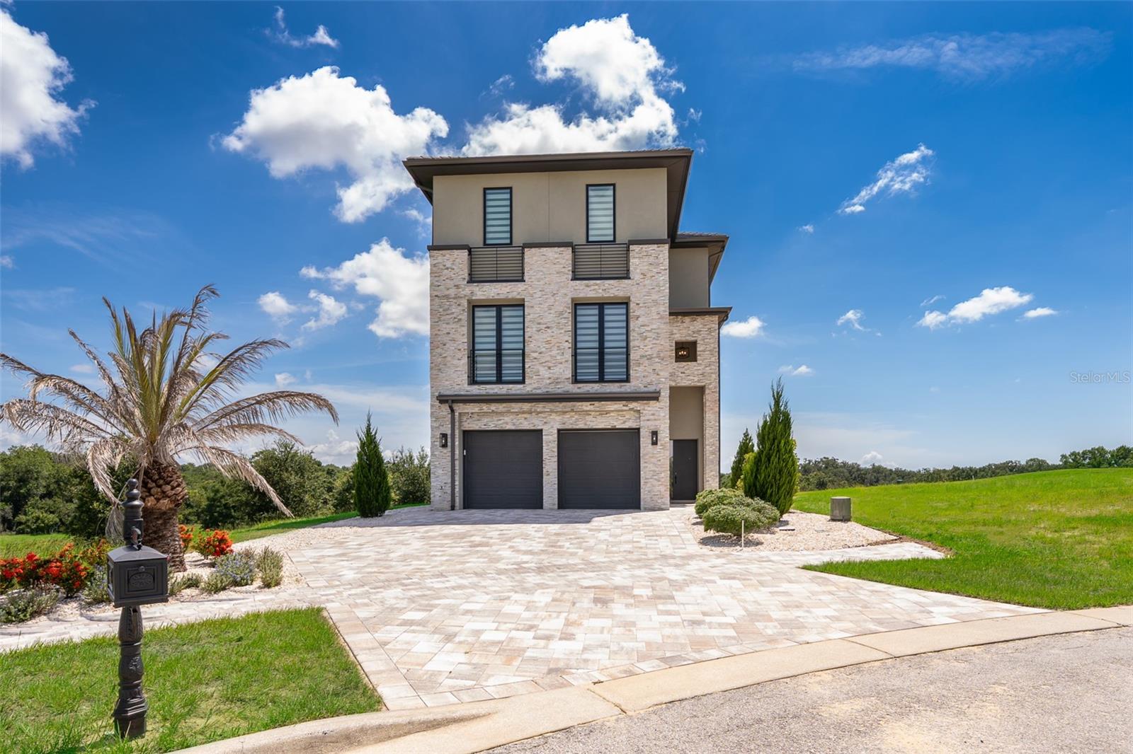 Step into elevated living in this extraordinary corner-lot, custom-designed estate, within a cul-de-sac, in the exclusive guard-gated community of Bella Collina. Spanning three luxurious levels, this 4BR, 5 Full BA, 2 Half BA custom home blends timeless elegance with modern sophistication, premium upgrades and panoramic golf views. The main level features soaring floor-to-ceiling, double-height windows and expansive glass doors allowing natural light to flood the space throughout the day. The oversized sliding glass doors seamlessly blend indoor and outdoor living as they open directly to the saltwater, heated pool & spa and patio area with lush landscaping, offering unobstructed views and easy access for entertaining. This level offers an open living/dining area with a gourmet kitchen equipped with Thermador appliances, two sinks and a hidden, walk-in pantry with Miele washer and dryer.
The second floor offers a spacious bonus room with a Thermador beverage station and wet bar perfect for entertaining. On this level, you'll also find a frameless glass-enclosed office, a full hall bath and a guest suite with an en-suite bath (double sinks) and walk-in closet.
On the third floor, you'll find a luxurious retreat offering breathtaking panoramic views of the 9th hole of the Bella Collina golf course through its private oversized balcony. Your primary suite comes equipped with a personal coffee station with sink, a Thermador beverage fridge and an expansive custom-built, walk-in closet. The third floor also includes two additional bedrooms, each with their en-suite bathroom. The laundry room with a Samsung washer and dryer, sink and custom-cabinetry is conveniently located between the bedrooms. Some of the additional features in this stunning home include: wood floors throughout, alarm system, whole-house water filtration system, 2-car garage, pool half bath and pre-wiring for sound system. This home perfectly balances high-end finishes, technology, and elegant indoor/outdoor flow—set within the serene, amenity-rich setting of Bella Collina, featuring a Nick Faldo Championship golf course, a luxurious spa, Har-Tru tennis courts, pickleball courts, clubhouse, outdoor pool complex, cutting-edge fitness center with complimentary fitness classes, lake views and monthly culinary and/or wine events. Don’t miss the opportunity to own this one-of-a-kind luxury retreat in Central Florida’s premier private community.