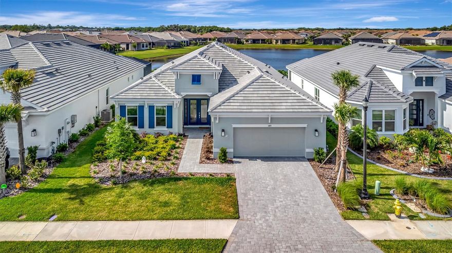 A striking blend of architectural detail, modern design, and tranquil water views defines this exceptional Palazzio model, offering over 3,000 square feet of refined living in one of Palmetto’s most sought after communities. From the moment you enter through the dramatic 12 foot entry with custom picture frame molding, your eye is immediately drawn through the home to the serene water views, creating a stunning first impression that carries throughout the kitchen, living, dining, and primary suite. The heart of the home is the extended chef’s kitchen, thoughtfully designed to balance beauty and function, featuring an expansive quartz island accented by designer pendant lighting, a full height quartz backsplash, GE Café appliances, gas cooking, a wine refrigerator, and reverse osmosis water filtration. This space opens effortlessly into the main living and dining areas, where a statement chandelier defines the dining space and the overall design creates a warm yet sophisticated setting ideal for both everyday living and entertaining. Designed to fully embrace the Florida lifestyle, pocketing sliding glass doors open wide to an extended screened lanai, creating a seamless indoor outdoor living experience enhanced by integrated indoor and outdoor speaker systems. The lanai, finished with brick pavers and a gas fireplace, becomes a natural extension of the living space, perfect for relaxing or entertaining while enjoying the tranquil water views. Hurricane impact windows and doors add both comfort and peace of mind, and the home is located in a non flood zone for added confidence and long term value. Luxury vinyl plank flooring enhances the main living areas, while a thoughtfully designed den or flex room with a shiplap feature wall provides a versatile space for a home office, media room, or private retreat. The owner’s suite is a peaceful sanctuary, positioned to capture water views and offering generous space, a spa inspired bath with dual vanities and walk in shower, and a large walk in closet designed for optimal organization. Bedroom two serves as a private en suite with its own walk in closet, while bedroom three features a pocket door, allowing it to function as a private guest suite with convenient access to a full bath. Additional highlights include a well appointed laundry room with built in cabinetry and a spacious two car tandem garage featuring epoxy flooring and upgraded lighting, with flexible space ideal for exercise equipment or a golf cart in this golf cart friendly community. Located within Esplanade at Artisan Lakes, residents enjoy a true resort style lifestyle with two pools, two clubhouses, fitness facilities, tennis, pickleball, and a vibrant social calendar, all conveniently located near I 75 and within easy reach of Tampa International Airport, Sarasota Bradenton International Airport, and St. Pete Clearwater International Airport, providing exceptional accessibility while maintaining a peaceful, resort style setting. Experience the lifestyle, space, and elevated design this exceptional home offers and schedule your private showing today.