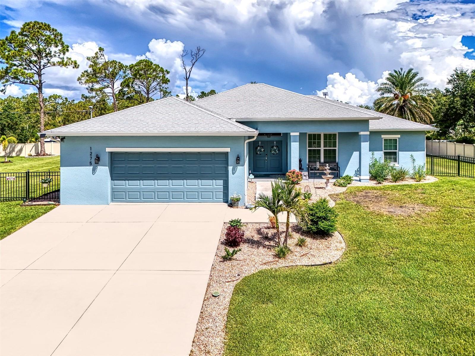 Homebuyers Seeking a RECENTLY CONSTRUCTED, ELEGANT CUSTOM BUILT (2023) 3 Bedroom, 2 Bath + Den HOME with an OPEN FLOOR PLAN, HIGH CEILINGS and COFFERED Great Room Ceiling, PRIVACY, NO HOA FEES, NO CDD FEES . . . PLUS . . . Situated on a TRIPLE LOT HOMESITE Measuring (240'x145') Just Under One Acre of Land (.80 Acreage) . . . You Have Found What You've Been Looking for! This GEM has An ATTACHED OVER-SIZED 2-Car Garage (23'X21.8') Plus a DETACHED GARAGE (18'X26') with Electric, Lighting and Workshop Space. RV and BOAT Owners . . . Bring Them Here. . .You’ll have Plenty of Room to Park and Hook Up to the 50 Amp Pedestal. This Remarkable Property is TOTALLY FENCED for Pets and Play, with PRIVACY VINYL on Back and Sides with ALUMINUM FRONTAGE for Great Curb Appeal. A Modern COASTAL DESIGN and PREMIUM FEATURES Create a Home that Truly Stands Out. TOP-OF-THE-LINE LUXURY WHOLE-HOUSE ECO WATER REVERSE OSMOSIS SYSTEM Gives Peace-of-Mind for Cooking, Drinking Water and Showering for the Entire Family. When Inclement Weather Approaches, You’ll Have No Worries as this Home has HURRICANE IMPACT WINDOWS and HURRICANE IMPACT TRIPLE SLIDER! And, If You Lose Power, there’s a GENERATOR HOOK-UP. Relax in the Great Room with Family and Friends as You Gather Around the Touchstone Elite Electric Fireplace Providing (with Heater) an Ambient Atmosphere. A Dream GOURMET KITCHEN Features SMART OVENS, Soft-Close 42" Cabinets, Tiled Backsplash and SAMSUNG Appliances (2023) plus a Beautiful Stainless Range Hood are Showcased in the OPEN FLOOR PLAN with an OVER-SIZED GRANITE Kitchen Island and a Coffee Bar. Upgraded PORCELAIN TILE Throughout ALL Public Rooms and LUXURY VINYL FLOORING in ALL Bedrooms and the Den/Study Makes Vacuuming a Breeze. For the Pets in Your Family, Bath Time is Stressless, as the Laundry Room has a Pet-Friendly TILED-WALK-IN SHOWER. . . Washup After Working in the Yard, or a Day at the Beach. A Security System is Also On-Site. Conveniently Located within Minutes of Shopping, Dining, Entertainment, Medical Facilities and Sports Venues. This EXCEPTIONAL OPPORTUNITY Awaits Those Who Want SPACE and PRIVACY, INDEPENDENCE and EVERYTHING COMPLETED to Begin Enjoying the Endless Possibilities of Keeping All of Your "Toys" with You! Call to See this AMAZING HOME and PROPERTY Today and Make It Your Own.