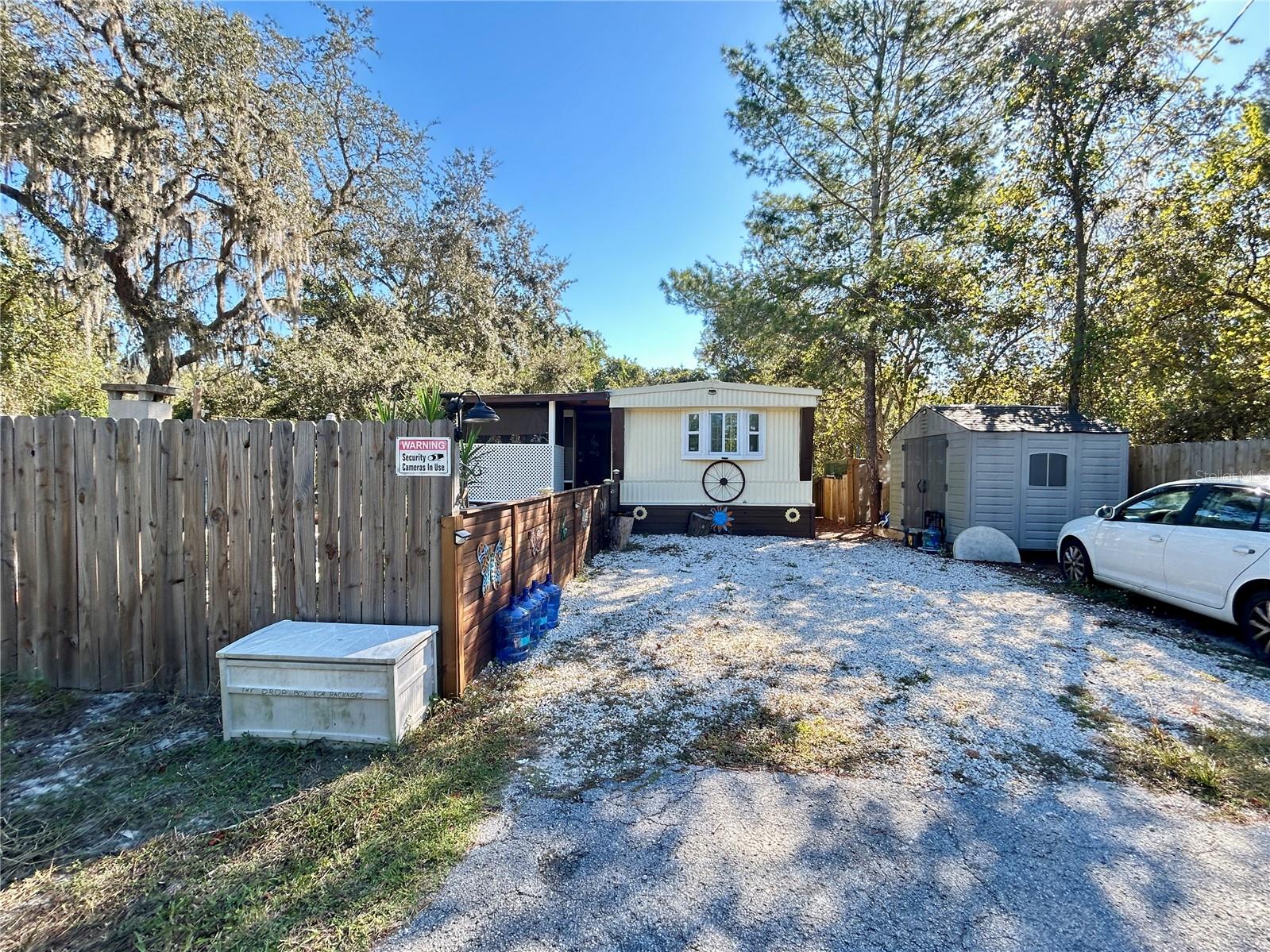 Enjoy peaceful country living in this beautifully remodeled 3-bedroom, 2.5-bath manufactured home, nestled in a quiet neighborhood surrounded by nature. Fully updated in 2022, this home blends modern comfort with rustic charm. Recent improvements include split cooling and heating units, a new hot water heater, soft-closing kitchen cabinets with matching butcher block countertops, stylish lighting and ceiling fans, and rich, wood-look waterproof vinyl flooring throughout. The bathrooms feature elegant gray porcelain tile and shower towers, while the home also offers updated windows, new insulation, textured walls, solid subflooring, and a durable metal roof for long-lasting protection.
Outside, enjoy your own backyard retreat with an above-ground pool, covered gazebo, and wood-fired pizza oven—perfect for entertaining or relaxing. The partially fenced property includes handcrafted decorative fencing, a netted garden, a chicken coop, two storage sheds, and an older RV (2000) ready for rebuilding. Practical upgrades include an updated electrical panel (2022), well pump (2022), and a 700-gallon concrete septic tank in great condition with an updated drain field.
Located outside the flood zone, with no HOA fees and no water bill, this home offers freedom, function, and the tranquility of country life. Schedule your private showing today!