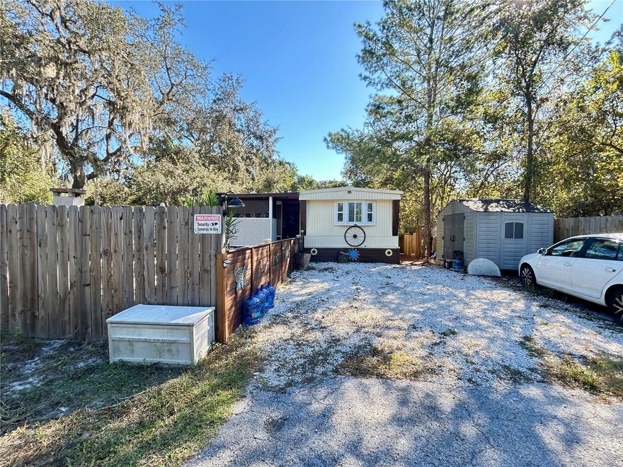 Enjoy peaceful country living in this beautifully remodeled 3-bedroom, 2.5-bath manufactured home, nestled in a quiet neighborhood surrounded by nature. Fully updated in 2022, this home blends modern comfort with rustic charm. Recent improvements include split cooling and heating units, a new hot water heater, soft-closing kitchen cabinets with matching butcher block countertops, stylish lighting and ceiling fans, and rich, wood-look waterproof vinyl flooring throughout. The bathrooms feature elegant gray porcelain tile and shower towers, while the home also offers updated windows, new insulation, textured walls, solid subflooring, and a durable metal roof for long-lasting protection.
Outside, enjoy your own backyard retreat with an above-ground pool, covered gazebo, and wood-fired pizza oven—perfect for entertaining or relaxing. The partially fenced property includes handcrafted decorative fencing, a netted garden, a chicken coop, two storage sheds, and an older RV (2000) ready for rebuilding. Practical upgrades include an updated electrical panel (2022), well pump (2022), and a 700-gallon concrete septic tank in great condition with an updated drain field.
Located outside the flood zone, with no HOA fees and no water bill, this home offers freedom, function, and the tranquility of country life. Schedule your private showing today!