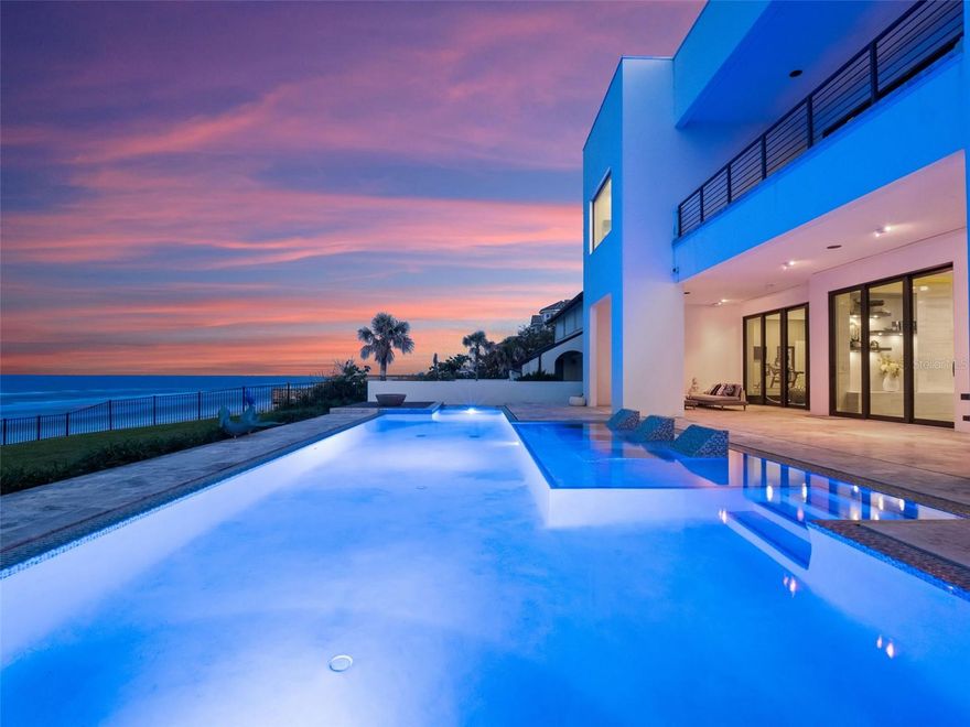 Oceanfront modern masterpiece. A modern architectural showpiece along the pristine coastline of New Smyrna Beach has entered the market. This home represents the pinnacle of refined coastal living, combining world-class design with exquisite craftsmanship and unparalleled privacy. Designed by renowned architect Geoffrey Mouen and completed in 2018 by esteemed luxury homebuilder Charles Clayton, this singular oceanfront estate encompasses 6,591 total square feet, including more than 5,700 square feet under air and a 900-square-foot three-car garage. Constructed entirely of brick atop 39-foot foundation piles and elevated to 19 feet above grade, the home was engineered with aesthetic distinction and structural integrity in mind. Framed by uninterrupted views of the Atlantic, the residence is a masterclass in modern minimalism, where soaring walls of glass dissolve the boundary between interior and exterior. A level-entry pool with solar heating, programmable color lighting, and auto-fill functionality anchors the outdoor living area, enhanced by a private beach walkover, new seawall, and curated landscape design. The interiors blend effortless sophistication with comfort, showcasing custom cabinetry by Central Kitchen & Bath, wide-plank flooring, and a seamless open-concept layout ideal for entertaining and quiet retreat. Highlights include a lavish primary suite featuring a wall of windows, fireplace, and a spa-style bath with soaking tub overlooking the Atlantic, oversized walk-in shower and an expansive dual closet with a center island. A bespoke bunk suite offers a flexible retreat for guests or extended family, while the chef’s kitchen, spacious great room, custom closets and private home gym cater to the most discerning lifestyle. Along one of Florida’s most coveted stretches of coastline, this custom residence stands as a testament to global inspiration and modern artistry. It is a one-of-a-kind retreat for those seeking refined architecture, coastal serenity and elevated living.