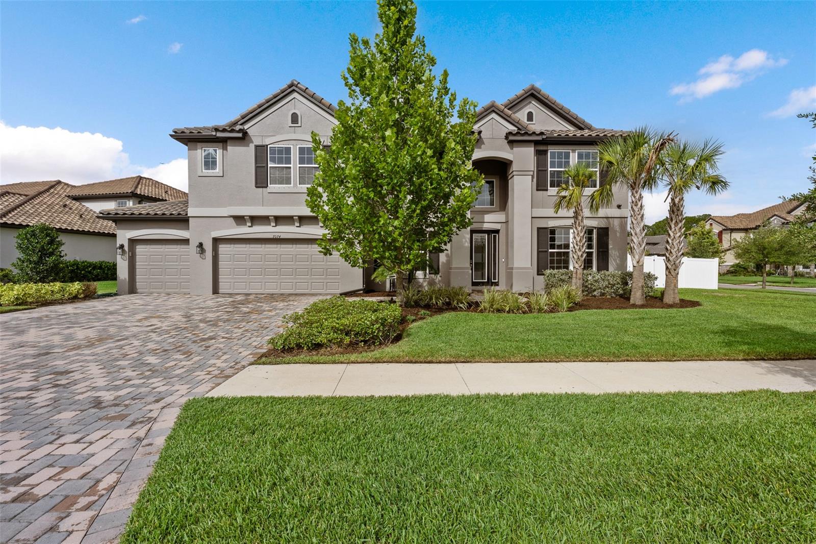 Introducing this expansive residence, resting on an even more expansive, rare and oversized corner lot within the exclusive gated community of Graybrook at Watergrass. This magnificent seven-bedroom, with four full and two half baths, dedicated office, bonus loft, four-car garage residence offers an unparalleled living experience, coupled with enjoyment of nearly ½ acre. Upon entering the dramatic two-story foyer, you are greeted by an atmosphere of refined elegance, accentuated by crown molding and tray ceilings. On one side, a designated office with a built-in desk wall provides a sophisticated workspace. The adjacent formal dining room, also featuring tray ceilings, sets the stage for memorable gatherings. The heart of the home is the gourmet kitchen, a chef's dream equipped with GE Profile appliances, a gas cooktop with a pot filler, and a stunning oversized quartz island that provides ample seating. Glass-display upper cabinetry and a walk-in pantry with a glass door add to the kitchen's allure, while a butler's pantry with a dry bar ensures seamless entertaining. The adjoining great room is a statement of style and comfort, showcasing a wood plank feature wall with a built-in decorative fireplace. The luxurious living quarters include two sets of Jack and Jill baths, providing convenience and privacy for family and guests. The oversized laundry room is a model of efficiency with its own counter and utility sink. Ascend to the second floor to discover an oversized loft, an entertainer's paradise, complete with a tray ceiling, a quartz island with a bar sink and a wine refrigerator. This versatile space opens onto a second-floor rear balcony, offering serene views of the massive backyard space. Go outside to the covered back patio, perfect for alfresco dining and relaxation. The home is also equipped with a dual-zoned air-conditioning system to ensure year-round comfort. The home's impressive curb appeal is enhanced by a four-car garage, complete with a tandem spot for additional storage or a prized vehicle, a tankless water heater, a water softener system and a convenient garage utility sink. Not in a flood zone. In the planned community of Watergrass, offering community amenities in the form of multiple community pools, clubhouse, fitness center, playgrounds, Watergrass Elementary and fire department, along with a new Publix and Starbucks. With nearby interstate access, this growing area also has the sought-after Innovation Preparatory Academy and The Kirkland Ranch Academy of Innovation schools while close to hospitals, dining and shopping options such as The Tampa Premium Outlets, KRATE at The Grove of Wesley Chapel and Shops at Wiregrass.