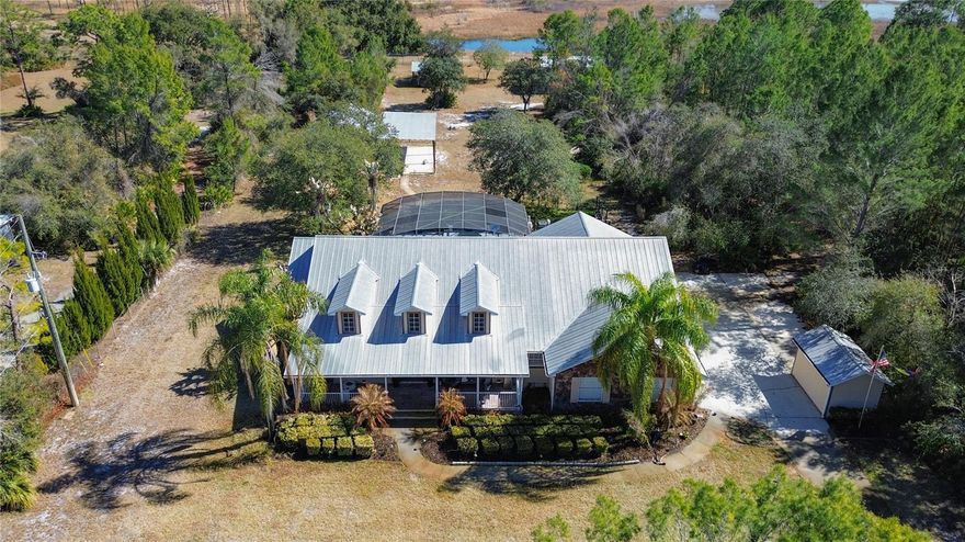 One or more photo(s) has been virtually staged. This exceptional four bedroom, three bathroom pool home offers space, privacy, and incredible versatility on 2.5 beautiful acres backing to conservation with no HOA. The spacious laundry room also functions as a mudroom and provides access to a large upstairs bonus room that can easily serve as a fifth bedroom, playroom, office, or flex space to fit your needs.

The recently updated kitchen feels like new and features upgraded appliances, a stunning panoramic window overlooking the property, a new island, and new cabinetry. Throughout the home you will find new flooring, updated light fixtures and fans, a custom living room built in with accent lighting and an electric fireplace, and beautifully remodeled bathrooms with glass showers and a new soaking tub. Upstairs, the loft includes a newly added bar area with pool table and upgraded lighting, creating the perfect entertaining space. There is also an office or guest room with a built in Murphy bed and custom cabinetry.

Step outside to your private backyard oasis featuring a heated pool with a new electric pool heater. The property includes an oversized three car garage with new built in cabinets and overhead storage. Multiple outbuildings provide endless possibilities, including a fully insulated and cooled shop currently used as a gym that could easily be converted into an in law suite. Attached covered storage areas are ideal for boats, RVs, and recreational vehicles, all situated on concrete slabs with both power and water available. A separate pole barn adds even more functionality, and a charming gazebo sits at the very back of the property.

The grounds have been thoughtfully enhanced with new landscaping, a fountain at the gated entrance, an electric gate, spot lighting around the home, and a new sprinkler system. A dedicated dog park with artificial grass adds convenience for pet owners. At the rear of the property, a garden showcases a wide variety of fruit trees including limes, lemons, bananas, plantains, cherries, figs, oranges, grapefruits, grapes, guavas, pineapples, and peaches.

With abundant storage for all your vehicles and recreational toys, a new AC unit, and eligibility for USDA financing, this one of a kind property combines modern upgrades with peaceful country living.