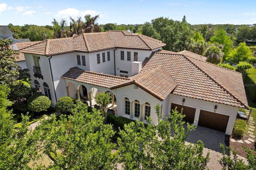 One or more photo(s) has been virtually staged. One of the only large-lot, water-facing estate homes in Baldwin Park, offering a level of privacy, scale, and setting that rarely becomes available. Tucked along one of the neighborhood’s most desirable streets, this Mediterranean-style residence spans over 5,300 SF on more than one-third acre, with tranquil water views and no rear neighbors, creating a true retreat within the heart of the community. A private front courtyard with a gas fireplace provides a warm and inviting setting equally suited for quiet evenings or relaxed gatherings.
Inside, the home balances warmth and sophistication with hardwood and travertine flooring, custom finishes, and natural light pouring in through expansive windows and French doors. The great room anchors the home with a gas fireplace and built-ins, seamlessly connecting indoor and outdoor living.  The kitchen is designed for both everyday living and hosting...featuring marble countertops, custom cabinetry, a full Viking appliance suite, two oversized islands, a walk-in pantry, and a butler’s pantry with dry bar. An adjacent family/media room offers a more relaxed gathering space.  The first-floor primary suite is privately positioned with peaceful pool and water views, a sitting area, and a spa-like bath with soaking tub, walk-in shower, dual vanities, and an oversized custom closet. A secondary bedroom with en-suite bath, dedicated office, laundry room, and pool bath complete the main level.  Upstairs, three additional bedrooms, two with en-suite baths, are complemented by a spacious bonus lounge or retreat with built-in workspace.  Outdoor living is where this home truly shines. A covered, screened lanai with lounge area, dining space, and summer kitchen overlooks a resort-style pool and spa with dual fire features all set against a serene pond backdrop.  Additional highlights include a deep four-car garage, updated HVAC systems, upgraded electrical, updated plumbing, custom drapery and plantation shutters on all windows, whole-home audio, and full irrigation.  Located in Baldwin Park, this home enjoys a rare position on a quiet, low-traffic street surrounded by other luxury residences, offering a level of privacy and calm that is increasingly hard to find within the community. Just steps away, you’ll find the neighborhood’s vibrant downtown district with its shops, dining, and everyday conveniences, along with scenic trails along Lake Baldwin, community pools, parks, and a fitness center. Ideally situated, the home is also just minutes from Winter Park, Orlando, and both Orlando International Airport and Orlando Sanford International Airport.