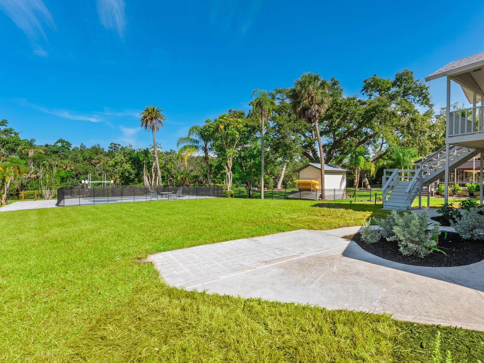 Enchanting waterfront lot, nearly 100 feet on the water, awaiting your new home. Oversized and already graded, this is an opportunity to build a dream home with new and updated luxuries, along with hurricane protections. This property has an existing dock and a 16,000-pound boat lift, so you are ready for a sunset cruise, or to just wet a line from your backyard. There is also a recently renovated swimming pool, along with a three-car garage, a tackle shack and a guest apartment, which is move-in ready. The original 1940s home has been demolished and is awaiting new construction. You will be tucked away at end of a quiet cul-de-sac, in a central neighborhood. Additionally, there is a cottage next door on a 17,500 square-foot lot, which is available for separate purchase. Combined, this would allow for a family compound or the construction of two new homes.