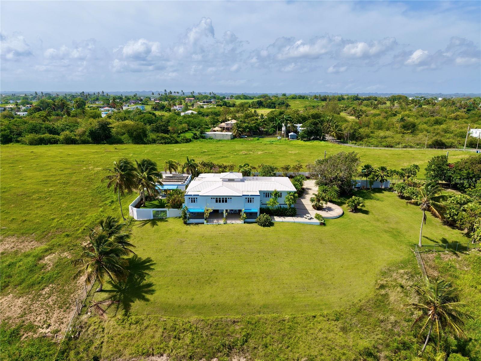 Perched on a dramatic cliffside, Villa ALMAR offers the most exclusive and unparalleled location in all of Isabela—a rare opportunity to experience privacy, elegance, and sweeping ocean views in one of Puerto Rico’s most coveted coastal destinations.
Overlooking the iconic Montones Beach, this extraordinary estate spans 14,463.84 square meters (3.68 cuerdas) of prime coastal land, delivering unobstructed vistas of the majestic Atlantic Ocean. A spacious balcony invites you to savor the sea breeze and take in the lush tropical landscape that envelops the home.
The two-story residence boasts 5,715 square feet of thoughtfully designed living space, featuring 4 generously sized bedrooms, 3 full bathrooms, and a guest powder room. Crafted for both luxury and functionality, the villa includes three fully equipped kitchens, an expansive game room perfect for family entertainment, a private gym room, a 3-car garage, a laundry room, a spacious pantry, and additional storage areas.
The second floor offers a bright, open-concept layout combining living, dining, and kitchen spaces—ideal for hosting or relaxing. A cozy corner is perfectly suited for a home office or reading nook. The primary suite is a true retreat, featuring a walk-in closet and a soaking tub with a window view overlooking the ocean.
Sustainability and security are seamlessly integrated with a 5,000-watt solar photovoltaic system powered by 21 solar panels, a Tesla battery with 240-volt capacity, a 600-gallon water cistern, and reinforced security doors and windows.