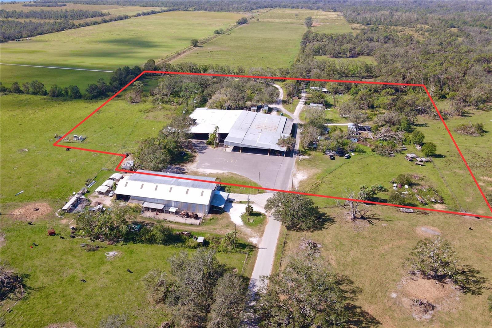 The Saffold Farms Packinghouse is an approximately 57,352 square foot vegetable packinghouse situated on 15.19 acres within both Parrish and Wimauma. It has four coolers totaling over 5,000 sq ft, multiple offices, three phase power, and one dock high ramp.
In addition to agricultural uses, permitted uses include farmworker housing; the sales, rental, leasing, storage, and repair of both heavy and light equipment; and lumberyard building materials.
The property is zoned A (General Agriculture) with a future land use of AG-R (per the Manatee County parcels), as well as AR (Agricultural Rural) with a future land use of A/R (Agricultural-Rural) (per the Hillsborough County parcel). The land is high and dry and outside the floodplain. Utilities are well and septic.
The property is located at 22701 Packinghouse Road, Parrish, FL 34219, at the border of Manatee County and Hillsborough County. It is situated in both Parrish (southernmost two parcels) and in Wimauma (northernmost parcel). Packinghouse Road is accessed via County Road 579 (Hillsborough County), also known as Saffold Road (Manatee County). The property is 5 minutes to SR-62, 8 minutes to SR-674, 10 minutes to US-301, and 20 minutes to I-75. With its close proximity to major roads, it is commutable to Wimauma (10 minutes), Fish Hawk (30 minutes), Bradenton (40 minutes), Tampa (45 minutes), Sarasota (50 minutes), and Tampa International Airport (55 minutes).