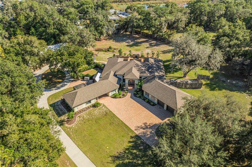 Experience unparalleled luxury and privacy on this stunning 2.75-acre COMPOUND, complete with a gated entrance and an impressive resort-style pool designed for ultimate relaxation. This extraordinary property offers a perfect blend of elegance, comfort, and functionality—an extremely rare opportunity in today’s market.

Step inside and be welcomed by a grand, spacious living room adorned with marble flooring that sets the tone for the home’s refined style. The gourmet kitchen features premium stainless steel appliances and a generous layout perfect for cooking and entertaining. A formal dining room provides an elegant space for memorable gatherings, while the family room—enhanced by a cozy fireplace—offers a warm, inviting atmosphere.

It is built for both leisure and entertainment with its dedicated theater room, game room complete with a pool table, and a private office ideal for remote work or study. The main home includes 3 bedrooms, 3 full bathrooms ensuring ample comfort for your family.

Additionally, an attached mother-in-law suite provides exceptional flexibility, offering its own bedroom and full bath—ideal for extended family, visitors, or multi-generational living.

Step outside into your own private oasis. The resort-style pool is complemented by an outdoor kitchen, fireplace, and spacious lanai—perfect for hosting gatherings or simply enjoying Florida’s beautiful weather. The large, fully fenced backyard offers endless possibilities, including garden space, a firepit area, and plenty of room to relax.

A separate warehouse adds even more value and versatility. With its own living area, one bedroom, one full bath, and an office space with its own half bath, it can be used as additional storage, an income-generating rental, or even a guest house.

Enjoy all of this with no HOA restrictions, giving you freedom and flexibility rarely found in such a luxurious property. Despite its privacy, the location offers incredible convenience—just minutes from major roads, SunRail, top-rated schools, shopping centers, and healthcare facilities.

This is truly a one-of-a-kind opportunity to own a property that delivers resort-level living, unmatched space, and everyday convenience. Don’t miss your chance to make this extraordinary estate your own.