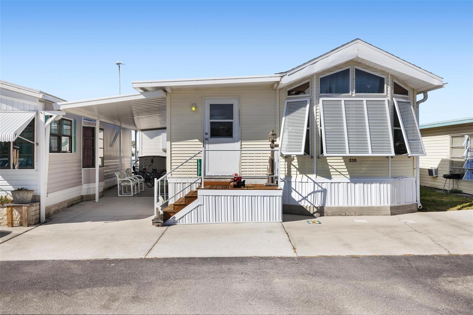 Welcome to Holiday Travel Park…where in this mobile home community, you OWN the land. And Located within 5 minutes of Englewood Beach, this 55+ community features pickleball, a pool, and a place to call home. Looking for a home located on an interior lot?? Step inside and Check this one out: featuring vaulted ceilings and an abundance of natural light, this tastefully decorated turnkey furnished home is ready to call yours! Featuring 2 BEDROOMS, 2 FULL BATHROOMS, and laminate floors throughout, this cute home is ready for its new owner! Did I mention this home has a tankless hot water heater and 220 AMP hookup? The ROOF: 2022 (Post Ian) - home also has hurricane shutters (Bahama style). Complete with a large sturdy carport and shed, this property can comfortable accommodate 2 vehicles. Schedule your showing TODAY to own your own little slice of paradise!