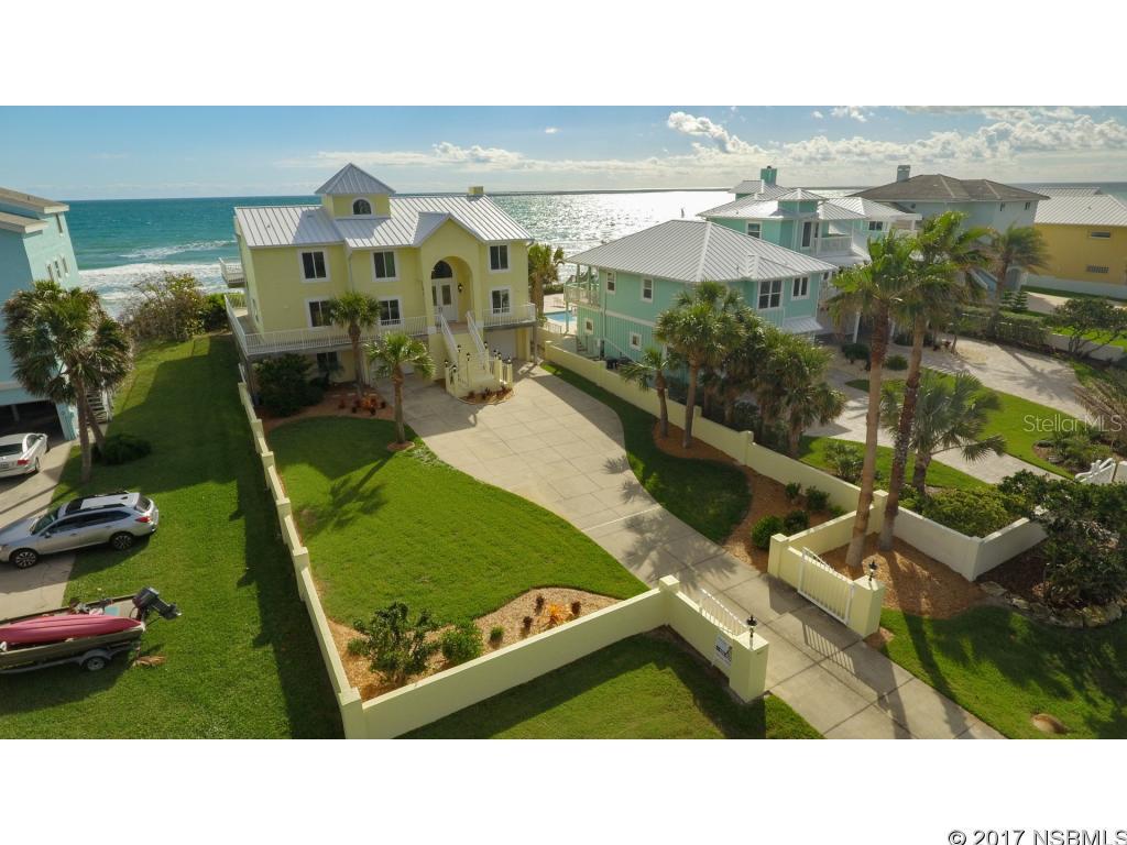 Enjoy the huge oceanfront deck and out door shower just a few steps down to the beach at this direct oceanfront 5 bedroom 4 1/2 bath 2 car garage furnished home. Mostly renovated in 2016/2017 except roof in 2014. What I like: Wide lot with space between you and neighbor. Luminous sunrises. Ground floor is set up for company or in laws with an ample kitchenette/laundry/1 Br/1ba and living area; 2nd floor has 1Br, 1-1/2 ba,LR,Kitchen, Den plumbed in for wetbar and surround sound...and a sunroom or Dining room, volume ceilings, all beautiful and open views to the Ocean with pale bleached wood look tile floors, winter white cabinets, and designer cut granite. Stainless appliances-hi end. The second floor opens to a spacious deep wrap around deck that leads over the Ocean rock revetment bulkhead to the shoreline and surf and has windows that reach for the sky. Lots of shells on the beach and few people. Hand selected furniture and accessories throughout. Ascending to the third floor, the North wing is filled with a generous Master suite with adjoining office with built in shelving on the west wall, 2 bdr/1 bath off the hall, and more outside decking complete the third floor. Amazing views, but better views up the staircase to the observation deck. The observation 4th level has a landing and door that lead out to a semi protected observation deck big enough to watch the Cape Canaveral launches , Whale watching, or have a small dinner party. There are 3 A/C systems, one for each floor. This is the best Oceanfront home I have seen under $2,500,000. This elegant Oceanfront home presents itself like a brand new home with the renovations just recently completed. Buy it today and move in tomorrow with this choice Ocean front opportunity move in ready home. Be here on the Ocean and never want to leave. ;Water: City