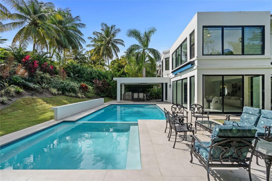 Bright, breezy, and beautifully updated 4-bedroom, 3.5-bath home in Dorado Beach East, the largest and most established community within the Dorado Beach Resort—home of the Ritz-Carlton Reserve. With 4,200 sq ft of total construction and 3,121 sq ft of interior living space, the property includes a bonus room off the primary suite ideal for an office or home gym.
New glass windows and sliding doors enhance natural light and complement the home’s modern feel. The kitchen offers an open layout that connects to the dining area and terrace, providing views of the outdoor space. The outdoor area is a standout, offering a modern pool surrounded by lush landscaping, along with an outdoor kitchen, gazebo, and spacious terrace perfect for entertaining.
Interior upgrades include new flooring, custom California closets, and a living area with high ceilings. Comfort highlights include a new rooftop central AC system, upgraded ductwork, rooftop dehumidifier, and eight independent AC units for flexible climate control.
Additional features include automatic sun awnings, a full-house generator, cistern, and rooftop solar water heater.
Dorado Beach East offers pools, tennis courts, basketball and beach volleyball courts, a private gym, game room, and direct access to world-class amenities within the Dorado Beach Resort—including championship golf, pristine beaches, fitness and tennis centers, water park, and premier dining. Available furnished or unfurnished, with an optional golf cart.