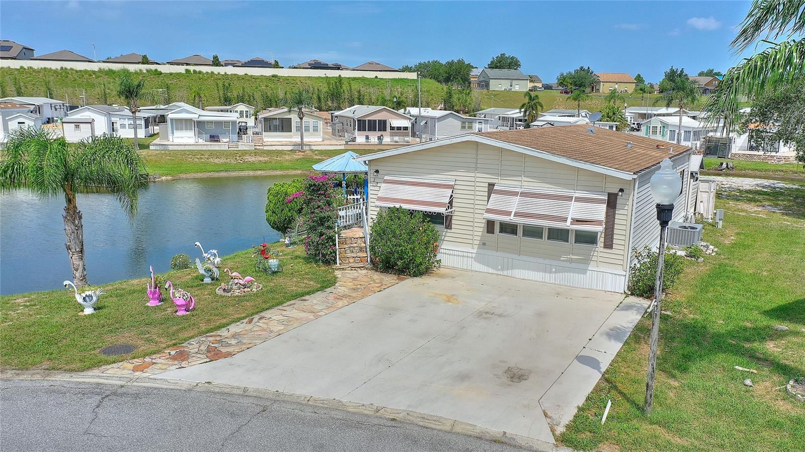 2/1.5 move-in ready. Gated community of Center Crest in Davenport. Own your own land. – Lakeside Lot! Low HOA
Welcome to your piece of Paradise in this sought-after 55+ community! This beautifully maintained 2-bedroom,1.5-bath home that sits on a unique peninsula-shaped lot with no rear neighbors and serene lake views. Enjoy peaceful mornings and evenings lakeside at the Gazebo.
This 2/1.5 offers an open floor plan with a spacious family room and a separate dining area. The large kitchen also boasts a breakfast bar and a custom wine/coffee bar — perfect for entertaining or relaxing. The primary bedroom is spacious. the main bath is located conveniently close to the guest bedroom Separate Linen closet in the hallway. There is a walk-in shower in the main bathroom with update tile. The second bathroom is located through the hallway ,close to the bedrooms.The home offers ample indoor and outdoor storage, plus both a side and back patio.
Other features include:
Updated walk-in shower
hurricane shutters
Private lot with no rear neighbors
Outdoor storage
Community amenities: clubhouse, pool, dog park and more
You own the land!
Don’t miss this rare opportunity to enjoy tranquil lakeside living in a vibrant community full of activities and amenities.