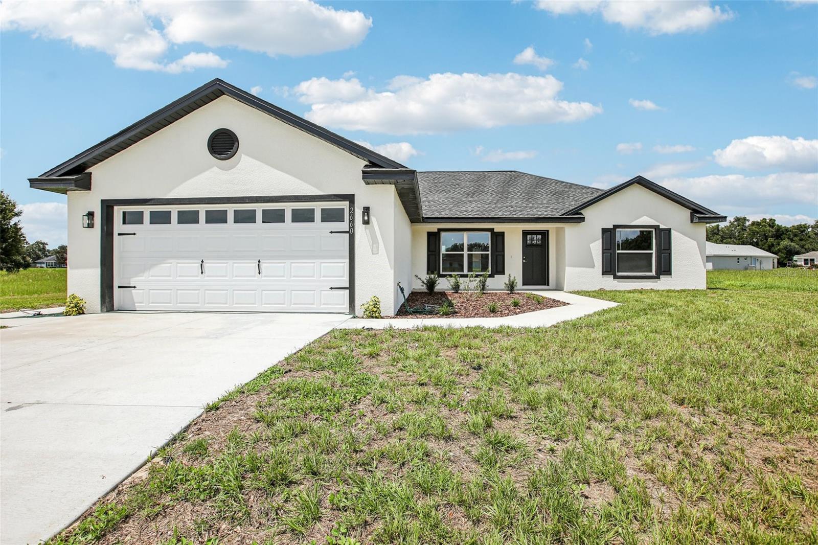 BRAND NEW & MOVE-IN READY! Be the first to own this freshly completed Chase model by Garrison Bailey Construction in Jumper Creek Manor. With 3 bedrooms, 2 bathrooms, and 1,884 square feet of stylish, low-maintenance living, this home delivers modern comfort — for less than you’d pay to rent.
Step inside to a wide-open floor plan with luxury vinyl plank flooring, elevated ceilings, and designer light fixtures throughout. The kitchen features white shaker cabinets, stainless steel appliances, and stone countertops, all bathed in natural light from a charming bay window breakfast area. Both bathrooms include floor-to-ceiling tile, and the oversized laundry room offers built-in storage and folding space. (We’re not saying we’re jealous of the laundry room… but we kind of are.)
Need a fenced-in yard for your favorite two- or four-legged companion? We can probably accommodate that. Don’t need a fence but dread lawn care? How about complimentary lawn care for a year? This builder is ready to make a deal — and that means you stand to benefit.
Other thoughtful touches include dual walk-in closets and a walk-in shower in the primary suite, hallway closet for extra storage or pantry, tucked-away utilities in the garage, and a covered back patio with open lawn views. Add in the charming front shutters and garage door hardware for just the right curb appeal.
Located in Jumper Creek Manor, a clean and well-maintained community with low HOA fees (just $395/year), public water/sewer, and access to city refuse collection. High-speed internet and cable available.
Best of all? You’re centrally located in the heart of Sumter County — just 1 hour from Tampa International or Orlando International Airports, and only 20 minutes to The Villages® for shopping, dining, and top-tier healthcare.
FHA, VA, and USDA loans accepted. First-time homebuyer and down payment assistance programs available for eligible buyers. Seller-paid concessions considered.
Easy to show by appointment — schedule your tour today!