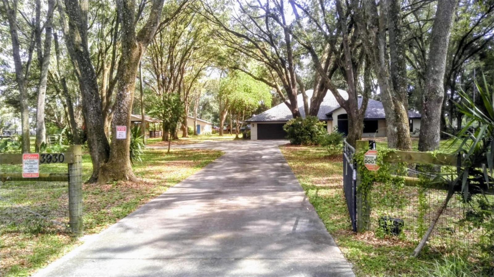 Welcome Home! This wonderful property offers TWO homes that each has their own house number. Over 2 acres that is fenced and crossed fenced. The main home is spacious with 3 bedrooms and 2 bath rooms, a huge family room, formal living and dining area. There is also a bonus room that could be used for an office or another bedroom. The master bath offers a garden tub, a shower and dual vanities. There are French doors that open out to an amazing screened in porch. The home has new flooring and paint throughout. The roof was replaced back in January of 2022. The drainfield to the main house was replaced about 1 year ago. The second home has 896 sq. ft of living area and features 2 bedrooms, 1 bathroom which also holds the washer and dryer, kitchen and a spacious living room. It also has its own electric. This would be perfect space for an In-Law suite, overflow area for guests or maybe even some extra income. There are two separate paddocks and a 3 stall barn for the animals and chicken coops for the chickens. For my horse lovers, Grand Oaks RV Park and L Cross Equestrian Center are just minutes down the road. You could also be at the World Equestrian Center in no time as well. Shopping and dining are also nearby. This home is in a great area and easy to show. Schedule your showing today!