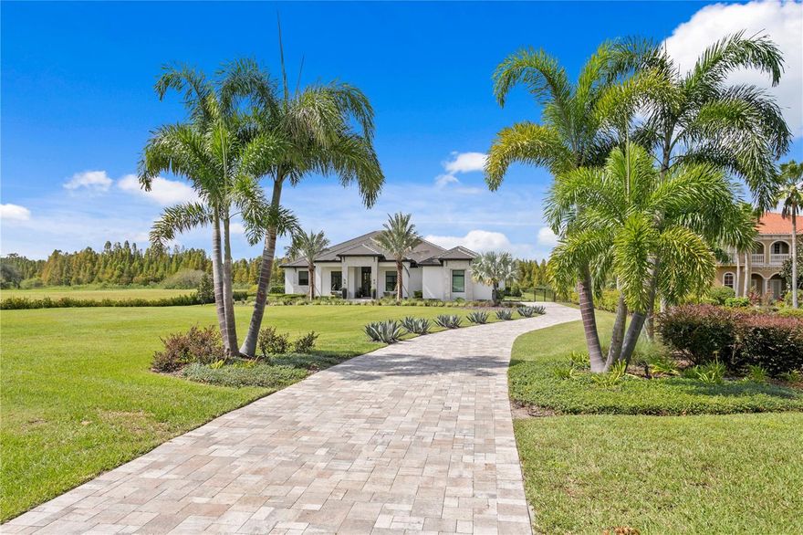 Nestled behind the gates of the coveted Stonelake Ranch community, this extraordinary custom residence sits on nearly 2 acres backing to a protected bird preserve and canal connecting to the largest lake in Hillsborough County. The crown jewel is the nearly $1 million Ryan Hughes Design outdoor living space — an infinity-edge pool, jetted hot tub with waterfall edge and loungers, swim-up bar, sunken lounge, water ledge with built-in umbrellas and fire feature, water feature wall, separate fire pit and seating, a fully appointed outdoor kitchen and dining pavilion, and an outdoor media area — all set against the serene backdrop of the preserve.  From the moment you turn down the long, palm-lined driveway — flanked by grand mature Royal Palms — you sense this home is something entirely different. An 18-foot porch ceiling announces the scale and craftsmanship within, drawing you into a soaring foyer that opens to the formal living and dining room — an entertainer's dream anchored by a gas fireplace, custom Henge lighting, and a wall of glass that frames the resort-style pool beyond. A walk-in refrigerated wine room by Cavà Vin completes the picture.

The thoughtfully designed split floor plan places the private primary suite and study on one wing, while the family room, game room, and guest suites anchor the other. The primary retreat features tray ceilings with cove lighting, a sitting area, pool-side sliders, dual custom closets, and a spa-caliber bath with floating soaking tub, artisan marble tile, walk-in shower, and a vanity crafted by Busby Cabinets — who also designed every cabinet throughout the home.

The chef's kitchen is equally appointed: Wolf gas cooktop, double Wolf ovens, Sub-Zero refrigerator, Scotsman nugget ice machine, a generous island, large walk-in pantry, and an eat-in nook overlooking the family room. Designer lighting by Ochre, McEwen, and Palachek elevates every space throughout.

For the most discerning buyer, this is the one.