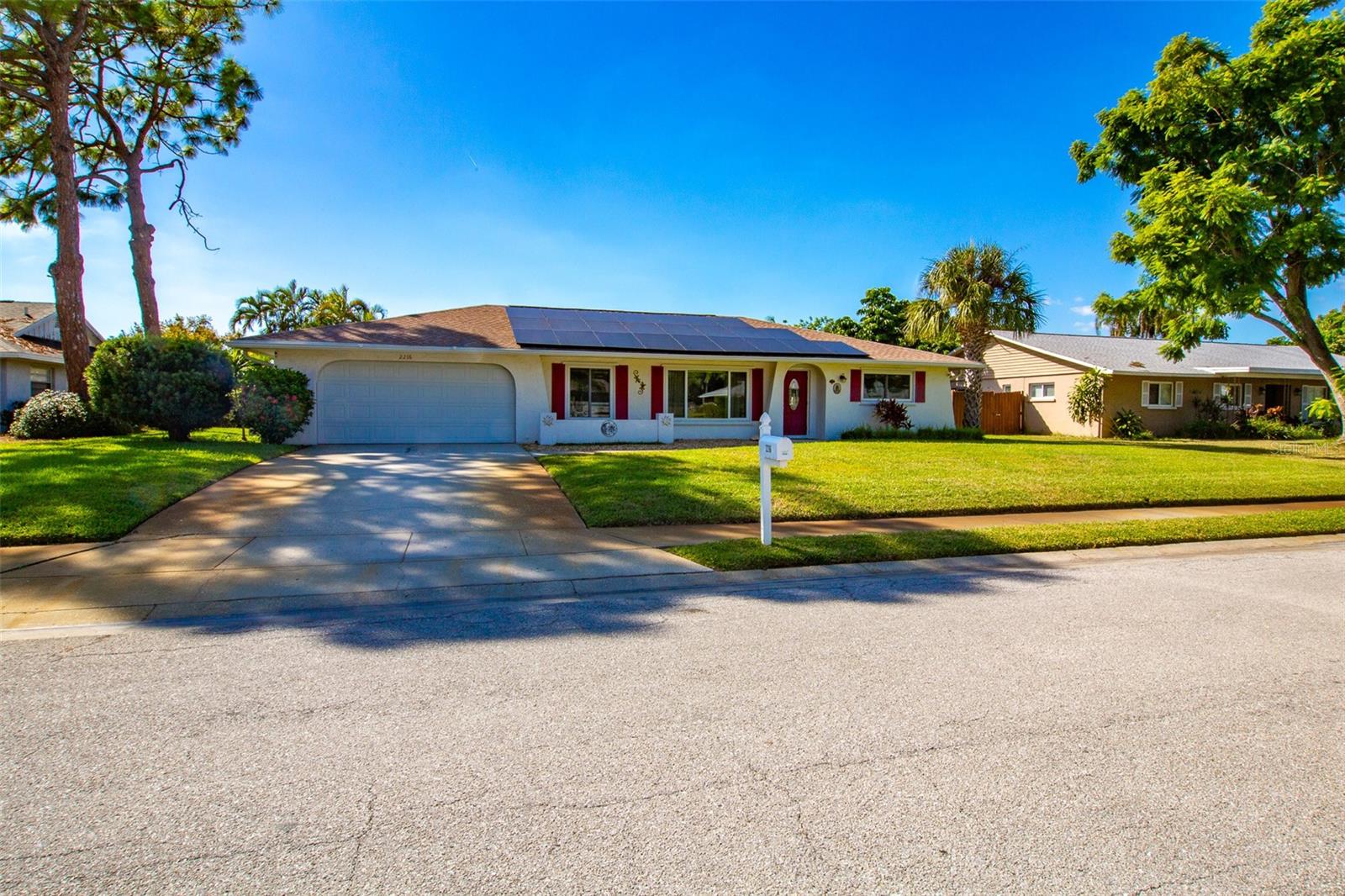 Located in the popular Pine Lakes community, this beautifully maintained 3-bedroom, 2-bath West Bradenton pool home is a true Florida retreat. Step inside to discover an inviting layout that seamlessly extends the warmth of the interior to the tropical outdoor living area.
A welcoming foyer entry opens to the formal living room featuring a custom-built entertainment wall and rich wood laminate flooring. The formal dining room provides the perfect setting for gatherings, while the spacious family room flows effortlessly to the expanded pool deck and lushly landscaped backyard. The backyard is ideal for entertaining or unwinding in your private oasis.
Enjoy the light-filled kitchen with a cozy breakfast nook, perfect for morning coffee while overlooking the pool and palms. The oversized master suite (19’ x 12’) offers a relaxing escape with a generous walk-in closet and tranquil views of the outdoor greenery.
Out back, the sparkling heated pool and spa invite you to enjoy the best of Florida living with its sun-soaked days, evening dips, and plenty of space to host family and friends. The fully fenced yard and tropical landscaping create both privacy and beauty, extending the home’s charm beyond its walls.
Lovingly cared for with numerous upgrades, including newer roof, windows, and whole-house solar system. This home offers comfort, efficiency, and peace of mind. No deed restrictions and an unbeatable location just minutes from the sugar-sand beaches of Anna Maria Island, shopping, dining, golf, and medical facilities.
This delightful residence is move-in ready and waiting for you to call it home!