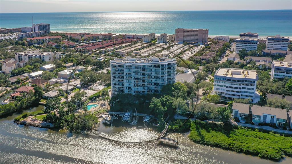 Secluded Siesta Key BAYFRONT condominium UPGRADED with PRIVATE BEACH ACCESS to the renowned Siesta Key Beach! Located in the gated community of Summer Cove, this 3 bedrooms with en-suite baths, and ½ bath residence is spacious with a large open floor plan, encompassing nearly 2500 sq ft. Enclosed garage parking for two, leads to a secure lobby with elevator whisks you to your private foyer entrance. This condo on the north end of the building is filled with light, thru its sliding impact glass doors and multiple windows on every exterior wall. There are three separate balconies that wrap the home, adding over 1000 sq ft of outdoor living space to enjoy and use for entertaining. The condo is well designed with great flow, with the main living spaces all opening to each other as well as to the outdoors, and is surrounded by windows. The primary suite faces the bayside and has it's own private balcony to sit and watch the boats go by. The primary bath has been remodeled and has dual sinks and upgraded designer tile. There are two walk-in closets. The secondary bedroom also have redesigned baths and huge walk-in closets. There is another balcony off the back bedroom. Thru the large laundry room, there is a service elevator and a separate entrance to the home that can be used in multiple ways from mud room entrance, hobby area, or another decorated second entrance. The options are endless. Currently it hosts the current owners fishing hobby tools and work area. MANY UPGRADES including, opening up the kitchen and addition of wine frig; replaced flooring throughout main living space to porcelain tile; newer carpet in bedrooms; remodeled primary bath; stone sink in half bath mounted on custom handmade cabinet; remodeled secondary baths; major remodel in 3rd bedroom to include the balcony and increase bedroom size. Newer appliances include: Refrigerator 2022, Air Conditioner 2020, Water Heater 2022. Summer Cove is a wonderful amenity-filled community on 3.5 landscaped-designed acres. It's clubhouse was designed by the world-renowned architect Carl Abbott in the Sarasota School of Architect style, and was the original home to the Summerhouse Restaurant. It is listed in the historic registry of Sarasota. Amenities include a fitness center, large summer room, conference room, catering kitchen and billiard table. There are 2 assigned spaces in the private enclosed garage, and caged storage nearby. On the bayfront, there are private boat docks and a pier on the bay, along with a platform kayak/paddleboard lift. The pool and spa are nearby with a grilling area and ice machine to make getting ready for your outdoor entertaining a breeze.