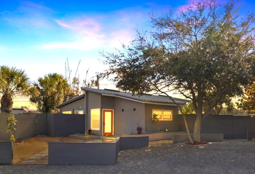 Step into this striking modern industrial home with a touch of boho-chic style — a thoughtfully curated blend of design elements that delivers a true wow factor from the moment you walk in. Soaring vaulted ceilings, an impressive open floor plan, and abundant natural light streaming through large windows, glass doors, and skylights create a bright, airy atmosphere that feels spacious without the upkeep of a larger home.

The kitchen is warm, open, and inviting, featuring high-end appliances, an under-mount sink, butcher-block countertops, and exceptionally efficient storage, including innovative drawer-within-drawer organization to maximize space. A rare and delightful feature of this home is that each bedroom offers private double-door access to the backyard — perfect for stepping outside to enjoy the weather or seamlessly blending indoor and outdoor living.

The beautifully updated bathroom showcases both style and function, with custom built-in storage cleverly integrated into the décor, a handcrafted dual-sink vanity, a high-efficiency low-flow toilet, and a stunning glass walk-in shower with rainfall showerhead.

The living room continues the home’s open, light-filled feel, highlighted by six hurricane-rated glass doors that fully open to extend the entertaining space onto the oversized back patio. Outdoors, you’ll enjoy a generously sized fenced backyard — ideal for hosting, relaxing, or simply enjoying Florida’s beautiful weather in privacy.

Recent upgrades add both value and peace of mind, including a warranted metal roof, whole-house water filtration system, hyper-efficient tankless water heater, eco-friendly gravel driveway designed to support natural aquifer recharge, newer Samsung appliances (washer, dryer, refrigerator/freezer, and dishwasher), high-efficiency LED lighting, and refreshed landscaping.

Conveniently located just over three miles from powdery sands of both Treasure Island Beach and St. Pete Beach, a short drive to award-winning Downtown St. Petersburg, approximately 1.5 miles from Stetson Law School, and minutes from shopping, dining, banking, and everyday essentials — this home offers exceptional access to everything the area has to offer.

If you’re ready for something refreshingly different from the ordinary, this distinctive, thoughtfully updated, and inviting home delivers both character and location — perfectly positioned between vibrant downtown living and world-class beaches.