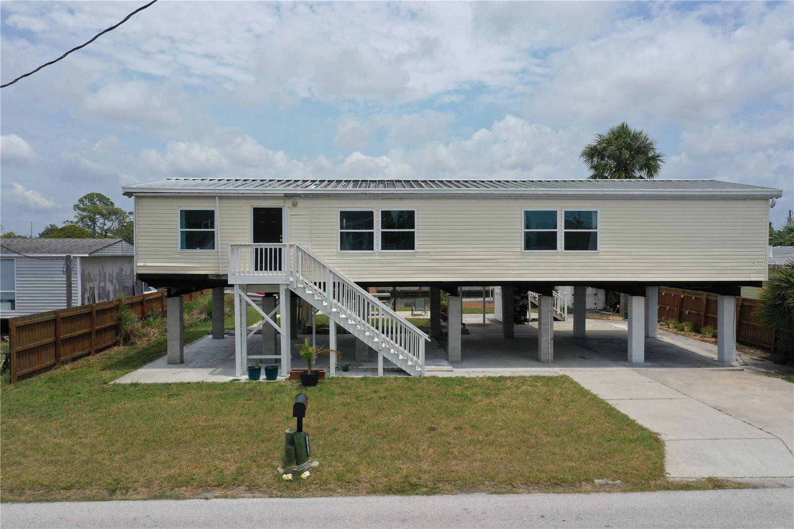 Looking for a rental that is updated, upgraded & on the water with access to the Gulf?!? This waterfront home, in Signal Cove of Hudson is what you have been looking for with 80 feet of seawall! This 1994 Palm Harbor Stilt Home is unrecognizable from what it was a couple of years ago while available and waiting for it's new owners! Driving into the neighborhood, you get the very sense that the water is nearby. Approaching the property, you'll notice the home is levels above the rest as a spot for relaxing & enjoying that Florida lifestyle. The backyard is spacious & provides a large, covered area for a break from the sun, a sun shaded seating area, large shed & not only a dock with boatlift & a floating dock but 80 glorious feet of seawall!! From the backyard, you can enter the home, via its composite built staircase into the front covered porch. Upon entrance of the home there is an open, airy feeling to the home that greets you inside, with its open floor plan offering a very large living room & dining area combination & the kitchen & breakfast are combination with a desk for convenience. The owner's suite is separate from the spare bedrooms while providing ample space for get togethers. The entire home has wood plank style tiling that runs through the entire floor plan providing consistency for your eye & as well as your sanity. The large owner's suite has a large closet, large window for lighting, a ceiling fan & a private en-suite that is sure to please with its separate shower stall, upgraded wooden vanity, fixtures & hardware while featuring a gorgeous stand-alone tub! Back out to the living room there is a large window, ceiling fan & enough space for the largest of sectionals or couch sets with a full ensemble. There is an open dining area near both the living room & kitchen while the kitchen boasts a breakfast area, a nook with desk & storage, quartz countertops, upgraded stainless steel appliances, solid wood cabinetry, updated fixtures & hardware. Just past the kitchen & delving deeper into the home is where you will find the 3 spare bedrooms, laundry room with exterior exit that can also be used to enter the home & a full updated & upgraded bathroom. The first spare bedroom provides a ceiling fan & a large window while being closest to the kitchen. The second spare bedroom is nearer the full bath & offers a view of the water, through it's window, while having a standard closet & ceiling fan. The third spare bedroom is nearest to the laundry room & linen closet & has a window & no closet. The full spare bathroom has an upgraded glass enclosure shower, wood vanity, framed mirror & upgraded hardware & fixtures. Being only 27 miles from Clearwater beach & 69 miles to Disney World this property should be your next home tour. If you have been looking for something with water frontage & easy access to the Gulf of Mexico, well hear you have it!