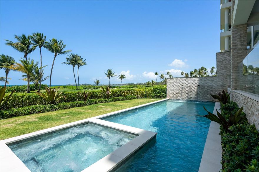 Feels like a home by the sea, park at your doorstep, skip the elevator and step directly into your private residence. From there, flow out to your own pool, lawn, and beach, a rare beachfront experience at the Four Seasons Resort & Residences Puerto Rico.  This first-floor garden residence spans 6,190sqft of indoor–outdoor living, designer-furnished by Hirsch Bedner Associates and move-in ready. Enjoy a private heated salt-water pool, spa jacuzzi, outdoor shower, and lush fenced yard. The Wolf/Sub-Zero kitchen includes a special-order double oven and connects to a fully equipped al-fresco kitchen for effortless entertaining. The primary suite features dual custom closets and a pre-plumbed wellness room ready for sauna, steam, or cold-plunge installation. Smart-home upgrades include Savant & Lutron automation and whole-home audio, paired with EV-ready parking and a 6-seat golf cart. Ownership includes the option to join the Four Seasons Resort & Residences Puerto Rico Hotel Service Program, offering access to five-star amenities, golf, spa, fitness, dining, and miles of nature trails—within Puerto Rico’s only Audubon Gold-Certified sanctuary. Owner financing available. Step from your private yard onto the shoreline and feel the Caribbean breeze, an effortless expression of luxury at Ocean Drive. This corner residence blends modern architecture with a relaxed island sensibility.
Floor-to-ceiling glass floods the open-plan living spaces with natural light, framing tropical foliage and the sea beyond. Retractable glass walls dissolve boundaries between indoors and out, opening to landscaped grounds perfect for morning swims or sunset gatherings.
The chef’s kitchen pairs Wolf and Sub-Zero appliances with Italian cabinetry and a generous island, while the adjacent outdoor kitchen makes entertaining under the stars effortless.
Private Quarters
The primary suite serves as a personal retreat with dual custom closets and a spa-inspired bath. A dedicated wellness space is prepped for sauna, steam, or cold-plunge installation. Three additional en-suite bedrooms—each with bespoke storage—ensure guests enjoy hotel-level privacy.
Smart & Turnkey
Integrated Savant and Lutron systems, whole-home audio, water softener, dedicated laundry, and private EV charging station elevate everyday ease. Two deeded parking spaces, a 6-seat golf cart, and 24-hour guard-gated entry provide convenience and peace of mind.
Four Seasons Resort & Residences Puerto Rico - Ownership includes privileged access to championship golf, farm-to-table dining, a state-of-the-art wellness and tennis center, full-service spa, miles of nature trails, and on-property water-sport adventures—all within the 483-acre, Audubon Gold-Certified sanctuary of Bahía Beach.

Whether you seek a legacy beachfront retreat or a capital-smart investment with owner financing, this Garden Residence delivers what discerning buyers value most: privacy, wellness, turnkey simplicity, and the prestige of a globally celebrated Four Seasons Resort address.