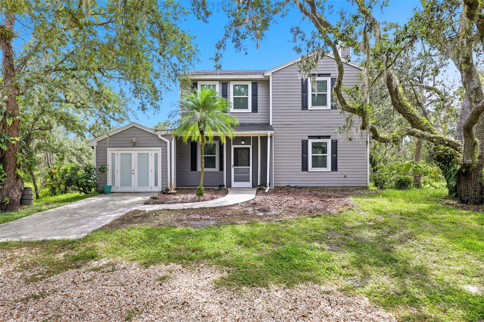 Welcome to your own private oasis. This 3 bedroom 2.5 bath home is seated on 2.23 acres of lush Florida landscape, featuring a personal creek boasting with wildlife. The home itself is renovated to the 9’s with luxury finishes throughout such as LVP flooring, quartz countertops and custom built-ins surrounding an active, stone-surfaced wood burning fireplace. The primary en-suite is very spacious with his & hers custom walk-in closet organizers and a stunning master bathroom with a sky light. This incredible home is only enhanced by the outstanding outdoor features. Some highlights include a sitting space with a fountain view, a foot bridge connecting your property across the creek, and a grand patio space to soak in all of the scenery. Additionally to the home itself, there are 3 buildings on the property, two of which are storage sheds and one is an outdoor workshop with two A/C’d rooms attached. Locationally, this house is ideally seated at only a quick 10 minute drive to Lakewood Ranch. Some important updates to highlight include 2019 new impact windows, 2020 Roof, 2022 A/Cs, 2024 Septic, 2024/25 well/pump. If you’re looking for country living meets your own Florida oasis, this home is for you.