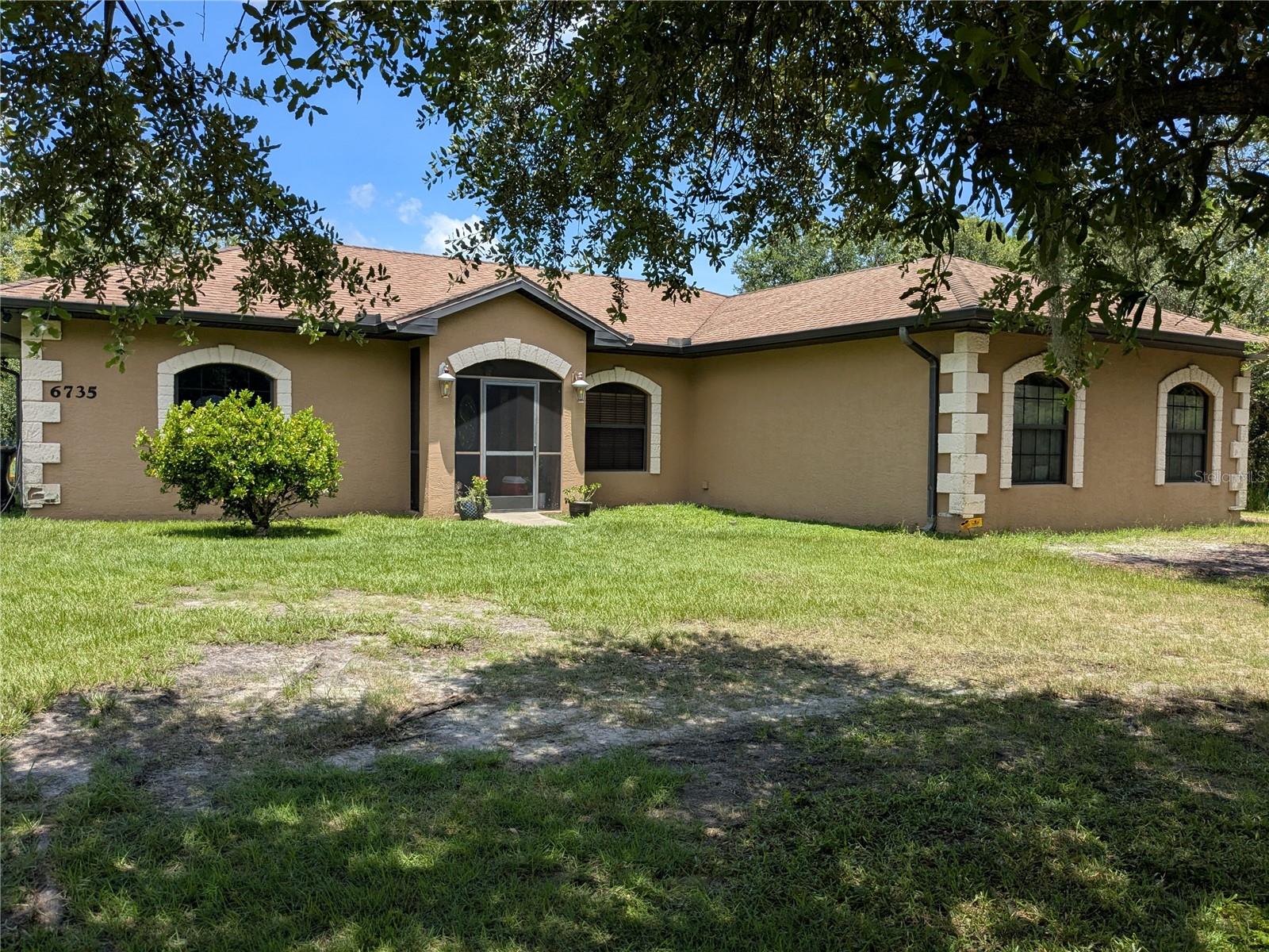 Custom-Built 3.2-Acre Estate with Pond, Tiny Home & Gorgeous Features Inside and Out! Looking for space, style, and plenty of extras? This 3-bedroom, 2-bath estate sits on 3 peaceful acres and is packed with features that make everyday living something to enjoy. From the moment you pull up to the screened front porch and pass through the lead glass entry door, you'll notice how much care has gone into every detail of this home featuring over 2,000 sq.ft of living space! Step inside and look up — the custom wood cathedral ceiling with exposed beams sets a warm, rustic tone that’s hard to find anywhere else. A stone gas fireplace in the family room brings charm and comfort, while wood flooring and wood-look tile stretch through all living areas for a clean, stylish feel. The formal dining room offers space for gathering, while the open kitchen includes solid wood cabinets with crown molding, granite countertops, a large breakfast bar, and an eat-in nook that fills with natural light. The master bedroom is a peaceful retreat with tray ceilings, custom crown molding, wood floors, and a walk-in closet. The master bath is a standout with a jetted tub, a Roman tile shower, wood cabinets, and more granite countertops. Two additional bedrooms feature tray ceilings, ceiling fans, and built-in closets. Step outside through the triple sliders to your spacious screened lanai, complete with a ceiling fan for comfort on warm days. Want to enjoy the outdoors even more? You’ll love the finishing pond, 16x12 tiny home that’s perfect for guests, large wire chicken coops, and 2 RV pads (one with power and water). The professionally landscaped yard includes fruit trees and a raised garden bed, ready for your green thumb. Other features include spray foam insulation throughout the attic, plant shelves, a brand-new A/C unit (will be installed before closing), and a location that’s close to schools, shopping, and dining. Minutes to I-75 entrance, and only a short drive to Sarasota and Fort Myers! Call now to schedule your private tour — this one won’t last!
