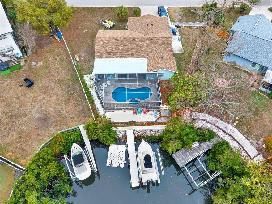 Waterfront opportunity in Apollo Beach! This 4-bedroom, 2-bath split floor plan home with a 2-car garage sits at the end of a canal offering privacy and great boating access. The property features a newer 10,000-lb boat lift, private dock, and even includes a boat, boat trailer, two Sea-Doos with trailer, and docking station—ready for your Florida waterfront lifestyle.

This Home did take on 10 inches with Helene and has been remediated and updated with ceramic tile throughout, new doors, and trim and drywall/sheet rock.

Enjoy your private outdoor oasis with a figure-eight style pool and a new pool liner and all of the equipment you need with it and center hot tub that overflows into the pool, all under a screened lanai with a new pool liner. Two bedrooms open directly to the lanai, creating seamless indoor-outdoor living. The primary suite includes a large walk-in closet.

Inside you'll find new flooring, trim, and doors throughout. The property also includes a 150-gallon propane tank already plumbed for grilling and a fenced side yard perfect for large dog breeds.

Existing kitchen refrigerator does not convey, the one in the garage will replace it. TVs do not convey wall mounts do not convey.

No HOA. No restrictions. Waterfront living and everything you need to entertain and live your best waterfront life.
Schedule your showing today and let's get you living on the water.

one or more photos may have been virtually staged.
