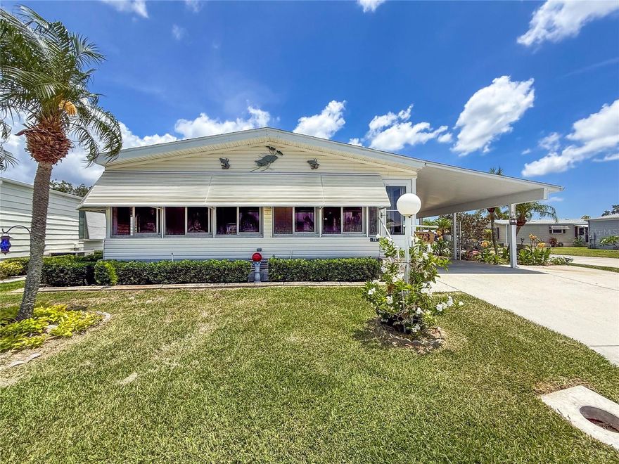 Beautifully updated 2bd/2ba home situated on a premier corner lot in the 55+ community of Ridgewood Oaks.  Fully landscaped with tropical flowers and hedge that are enclosed by decorative concrete edging all around the home. Huge 42’ x 12 covered carport with room for many cars or could be enclosed to create a garage.  Extra side concrete drive for a golf cart. There is a large workshop that also holds the home’s water heater.  The lanai is 28’ by 10’ with newer windows and features sliding glass doors into the living room and the kitchen areas.  Inside the home, there is new laminate flooring throughout all rooms and the extra wide (5’) hallway that goes from the living area to the double French doors of the primary bedroom.  All windows have been replaced with easy to clean double hung windows.  A remodeled kitchen with newer stainless appliances, custom cabinets and a dining nook area.  Both bathrooms have been remodeled and updated.  The primary bedroom is very large with plenty of room for oversized dressers and a king bed.  This is a very rare floorplan and has too many features to list.  The Oaks community includes Spectrum internet and cable in its fees along with weekly lawn maintenance.  A beautiful clubhouse, pool, spa, tennis courts, Pickle ball courts, shuffle board and a fun outdoor fitness area.  Golf cart and small pet friendly.  Ridgewood has close access to I-75, many restaurants, the Ellenton Outlet Mall, Manatee County Library and provides 24-hour gated security.  The Oaks, a Ridgewood 55+ community offers many activities and social events to enjoy.  All room sizes are approximate. All information is deemed reliable but should be verified by buyers and/or buyer's agent.