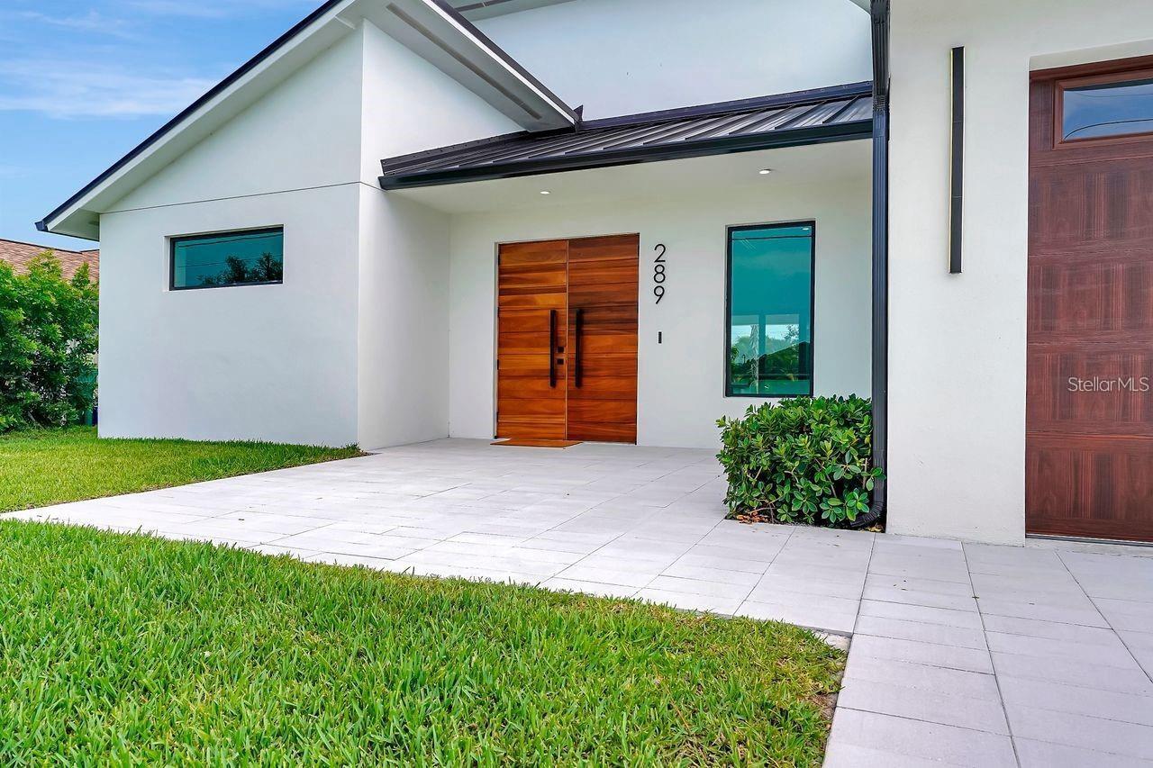 Step into modern luxury with this striking contemporary residence, perfectly situated in an exclusive neighborhood. This home is a seamless blend of style, comfort, and sophistication—designed to impress at every turn. From the moment you enter, natural light pours into the expansive open-concept living area, beautifully merging indoor and outdoor spaces. The neutral color palette, upscale finishes, and exceptional attention to detail create an atmosphere of refined elegance. At the heart of the home lies a gourmet kitchen, outfitted with top-of-the-line Samsung appliances and quartz countertops—ideal for both everyday meals and lavish entertaining. The space flows effortlessly into the dining area, making it perfect for hosting or enjoying quiet family dinners. The home offers three generously sized bedrooms, including two luxurious en-suite retreats. The split floor plan provides enhanced privacy, with the master suite serving as a peaceful sanctuary featuring a spa-inspired bathroom and walk-in closet. Designed for ultimate indoor-outdoor living, pocket sliding doors open to a spacious patio and stunning beach-entry pool—ideal for sun-soaked relaxation or stylish al fresco gatherings. A three-car garage adds both functionality and convenience, with ample space for vehicles and storage. Every aspect of this home has been thoughtfully curated to present an elevated living experience that exceeds expectations. Welcome to a new standard of elegance, comfort, and modern living. Special buyer incentives available with preferred lender.