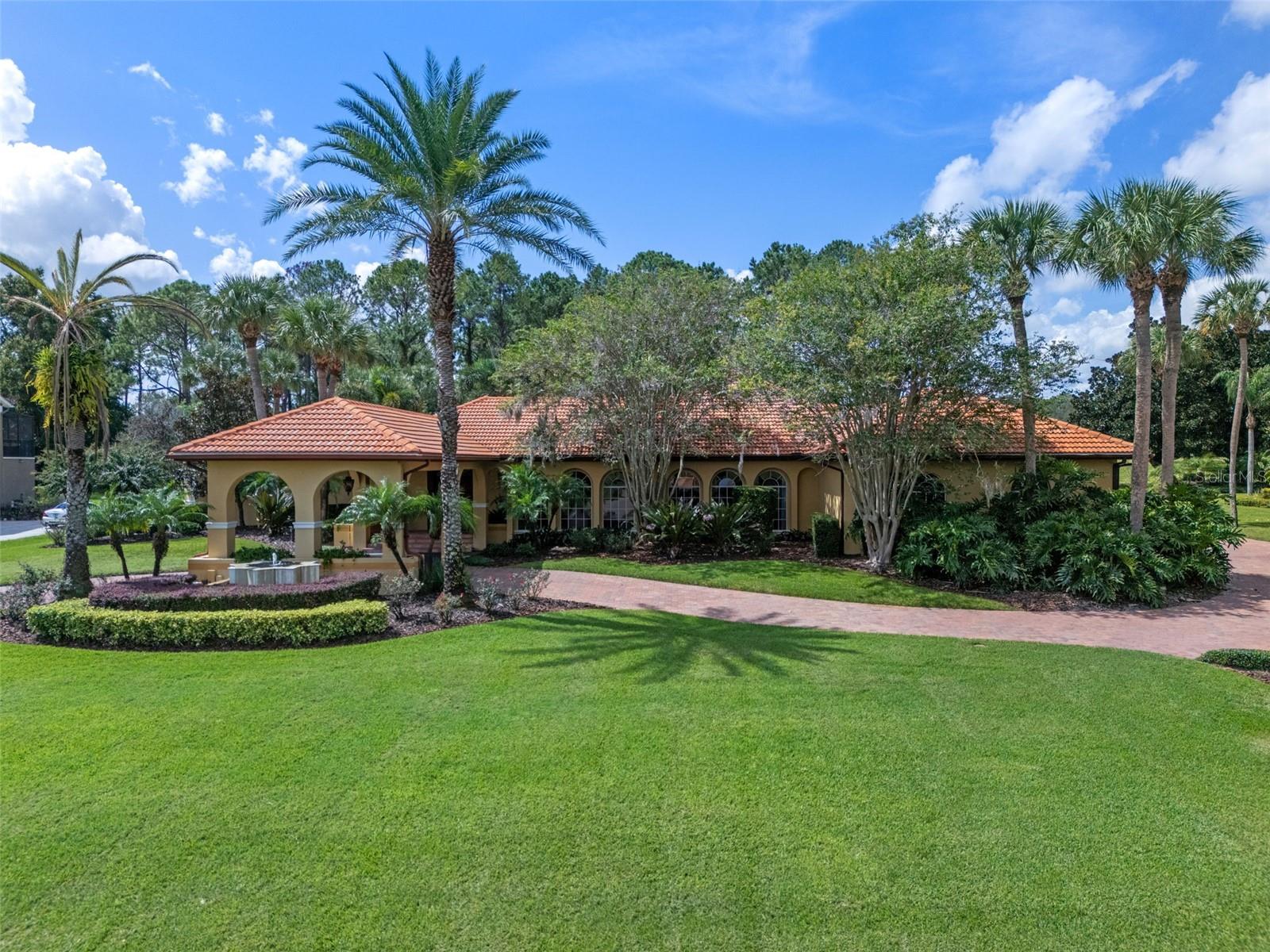 This one-of-a-kind estate in the gated Windermere Club combines timeless elegance with rare features seldom found in the area, including four garage bays—one of them detached with adjoining flex space that can serve as a gym, studio, or easily transform into private guest quarters or multigenerational living. A porte cochere and sweeping circular drive create a striking first impression and lead to an inviting foyer that opens to gracious formal living and dining rooms, perfect for entertaining. The primary suite is a private sanctuary, designed with pool views, a spacious sitting area, and a vestibule entry that includes a small room ideal for an office nook or personal retreat. The spa-inspired bath is beautifully appointed with dual vanities, a soaking tub, and an oversized walk-in shower, while two custom closets provide abundant storage. Equally thoughtful are the secondary bedrooms, each with its own en-suite bath. They are arranged along a wide hallway that can be closed off entirely, creating a separate wing that offers privacy and comfort for family or guests. At the heart of the home, the gourmet kitchen is both a showpiece and gathering place, featuring an expansive island, custom cabinetry, and intricate tilework beneath a statement hood, with a barn-style door leading to the pantry. The utility room includes built-in cabinetry and a utility sink for added convenience, while the family room offers relaxed living space with views that draw you outdoors. Just beyond, a patio with a charming wood trellis extends the living space and creates a perfect spot for quiet moments or intimate gatherings. The backyard was designed for resort-style living, with a sparkling pool and spa, dedicated pool bath, screened lanai, and a summer kitchen perfect for dining al fresco. Framed by lush green space and the peaceful backdrop of the former Windermere Club golf course, this residence offers a sense of privacy and serenity while being just minutes from top-rated schools, dining, shopping, and all that makes Windermere one of Central Florida’s most desirable communities.