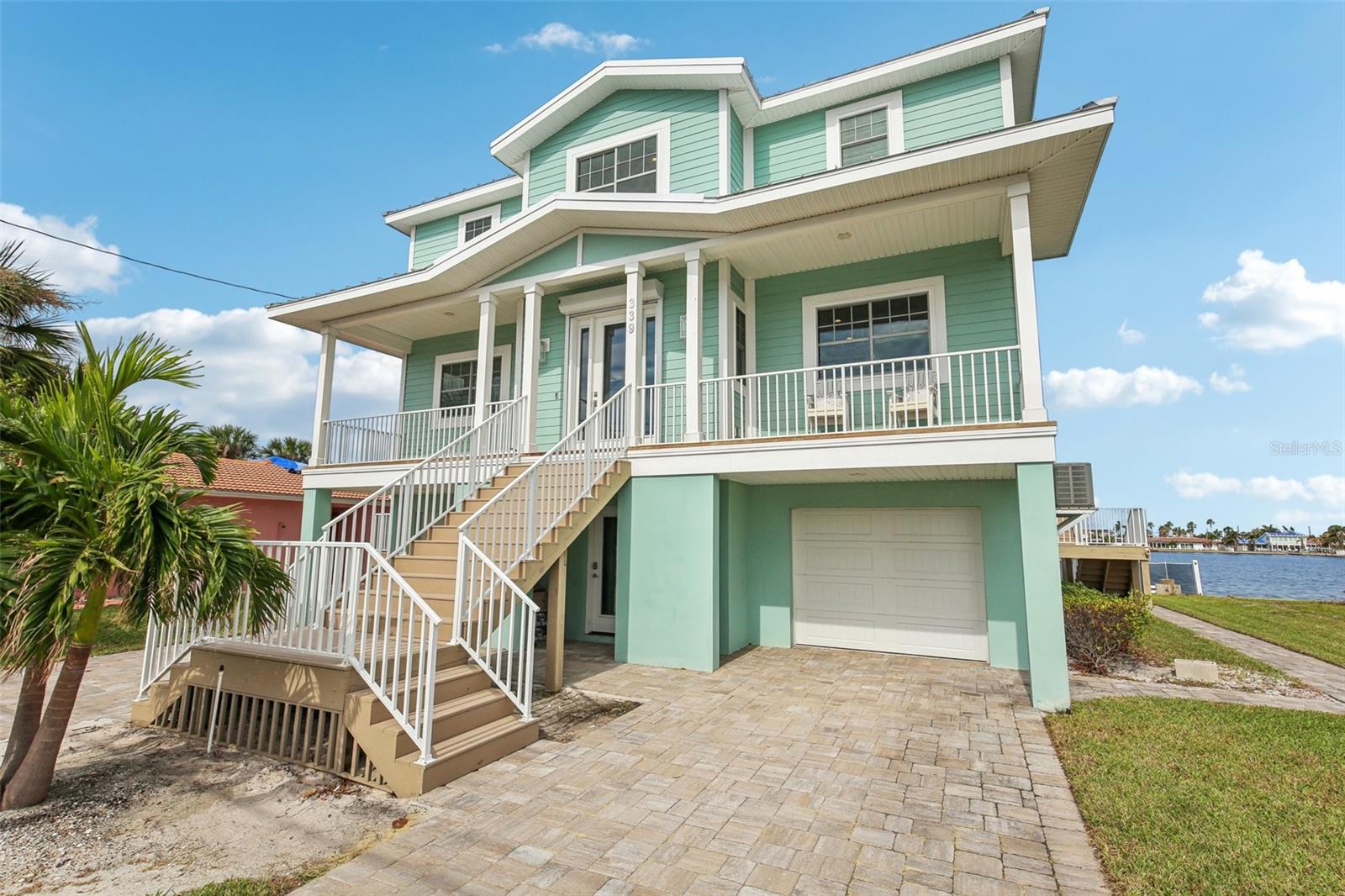 **HUGE Price Reduction!**
Step into coastal luxury with this beautifully elevated waterfront home, built in 2020 to meet the highest safety and design standards. Positioned 14 feet above base flood elevation and fully FEMA compliant, this home combines peace of mind with elevated style, featuring impact-resistant windows and a flawless track record through recent storms.
Inside, enjoy panoramic water views from nearly every room. The open layout is enhanced by custom closets, elegant indoor plantation shutters, and a warm wood-accented living area with a charming fireplace, thoughtfully updated in 2022. A UV light system added to the AC units ensures clean, healthy air year round.
The spacious outdoor decks, retiled in 2021, are ideal for entertaining or unwinding while overlooking tranquil water scenes. Boaters will love the 2023 dock with a 13,000 lb lift, water, and electric. A brand new seawall and whole home water filtration system installed in 2024 offer added confidence and comfort.
Additional features include hurricane shutters, a pristine epoxy coated garage, and low flood insurance thanks to the elevated design. Just a short walk to the beach and minutes from dining, this turnkey retreat includes stylish furnishings with a strong offer.
Live effortlessly, entertain beautifully, and enjoy the best of coastal living right here.