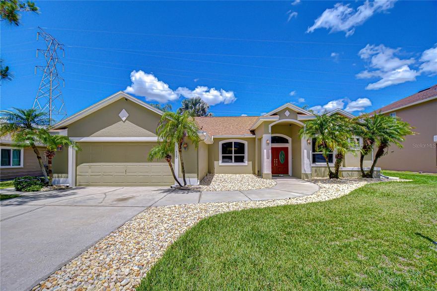 Seller is offering a $3,000 flooring credit. Tucked inside a quiet cul-de-sac where morning walks meet shimmering water views and golf course greens stretch beyond your backyard, this Northdale Golf Club pool home feels like a private retreat—yet lives like a gathering space.
Perfectly positioned with a scenic walkway, tranquil pond, and two tees just beyond the fully fenced yard, this 3-bedroom, 2-bath residence with a dedicated office/playroom and 2-car garage spans 2,110 sq ft of thoughtfully designed living space, where indoor comfort and outdoor beauty blend effortlessly. The 2-car garage is equipped with a 50-amp, 240V industrial-grade NEMA 14-50 outlet, EV-ready for convenient at-home charging. From the moment you arrive, the curb appeal makes a striking first impression. A paved driveway and gracefully curved walkway meander through beds of large stone river rock, contrasted by swaying palms rising from the manicured lawn, guiding you to a columned portico. Double front doors, with elegant oval glass inserts and a transom window above, create a grand yet welcoming entrance. Step inside to a soaring, light-filled foyer where openness and light draw you in.
To the left, the dining room invites memorable dinners, while straight ahead, the spacious living room showcases triple sliding glass doors framing the pool and bringing in light. Architectural details—rounded corners, graceful archways, recessed lighting, and smooth ceilings—create a refined yet relaxed aesthetic throughout. Set apart for privacy, the primary suite is a true retreat. Double doors—crowned by a recessed display niche—open to an inviting entry with an art niche, guiding you into the suite, while a separate hallway leads to the ensuite bath. The bedroom offers private access to the lanai and dual closets, including a walk-in with custom built-ins. The ensuite bath delivers a spa-like experience with a double vanity featuring undermount sinks, ample drawer and cabinet storage, a soaking tub set on a tiled platform framed by a large window, and a distinctive glass side window offering a subtle peek into the tiled walk-in shower. A private water closet adds comfort and convenience. At the heart of the home, the kitchen blends functionality with charm, featuring ample cabinetry with decorative plant shelves above, a built-in pantry, and a peninsula breakfast bar perfect for casual mornings or evening conversations. The adjacent café area, wrapped in tall angled windows, offers picturesque pool views, while a French door connects indoor dining to outdoor living. Just beyond the breakfast bar, the family room is highlighted by tall curved windows and sliding glass doors that open to the lanai and pool area, creating an easy flow for everyday living and entertaining. Beyond this space, the flexible office or playroom adapts to your needs—whether working from home, creating, or relaxing. The split floor plan provides privacy, with generously sized secondary bedrooms featuring ample closets and ceiling fans, along with a well-appointed guest bath. Step outside to see what makes this home unforgettable. A paver deck surrounds the saltwater free-form pool, complete with a sun shelf and bubblers that shimmer in sunlight. The screened enclosure offers year-round enjoyment, while two gated entries lead to a lush fenced backyard opening to sweeping golf course views and peaceful pond beyond—your own slice of serenity. Schedule your showing today and explore the possibilities.