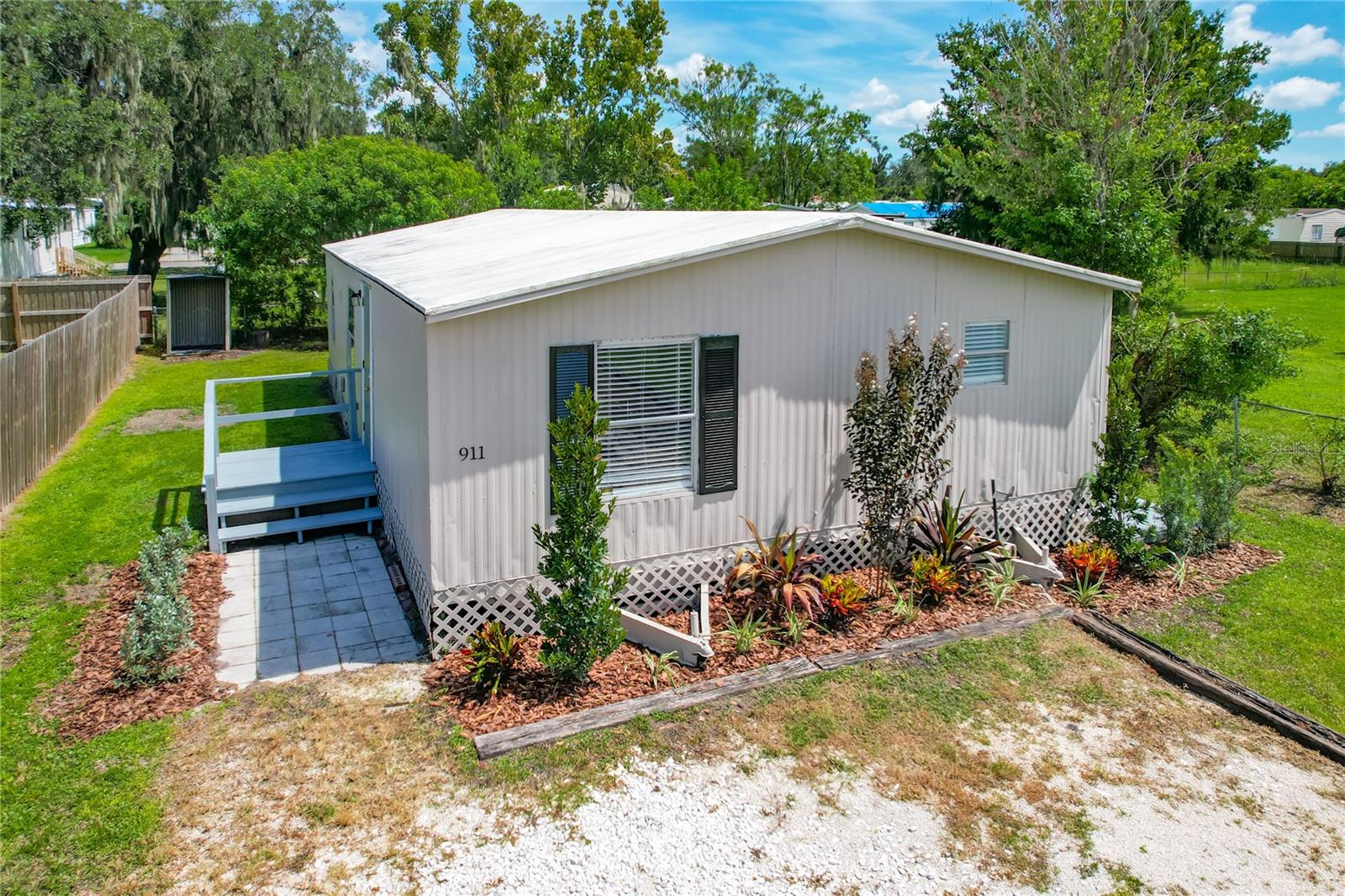 Beautiful 3 BED, 2 BATH manufactured home now available in small town, USA, Mulberry, Florida! This SPACIOUS 1440 sq ft home has received the best of care and has tons of MODERN UPGRADES: NEW LANDSCAPING, NEW PAINT INSIDE AND OUT, NEWER KITCHEN CABINETS and GRANITE COUNTERTOPS with room for barstool seating, NEW REFRIGERATOR, VINYL PLANK and TILE FLOORING (no carpet!), NEWER COATING on Bitumen Roof, LED LIGHTING, WATER-CONSERVING TOILETS in BOTH BATHROOMS, and more! The primary bedroom features a lighted WALK-IN CLOSET complete with convenient barn door entry, and there is an oversized tub/shower unit in the primary bathroom. There is a convenient indoor laundry room with W/D hookups and a side door exit. You’ll be sure to appreciate the oversized gravel driveway with PLENTY OF PARKING SPACE as well as a SIDE DECK for relaxing outside. There is even a small open shed and fencing on 3 sides! What a fantastic opportunity to own your OWN HOME on your OWN LAND, or you may be looking for just the right rental property to add to your portfolio. This property has amazing income potential, and there is no HOA or CDD to concern yourself with. If you’re looking for a TURN-KEY home with very little fuss, this is THE ONE. Schedule your showing today!