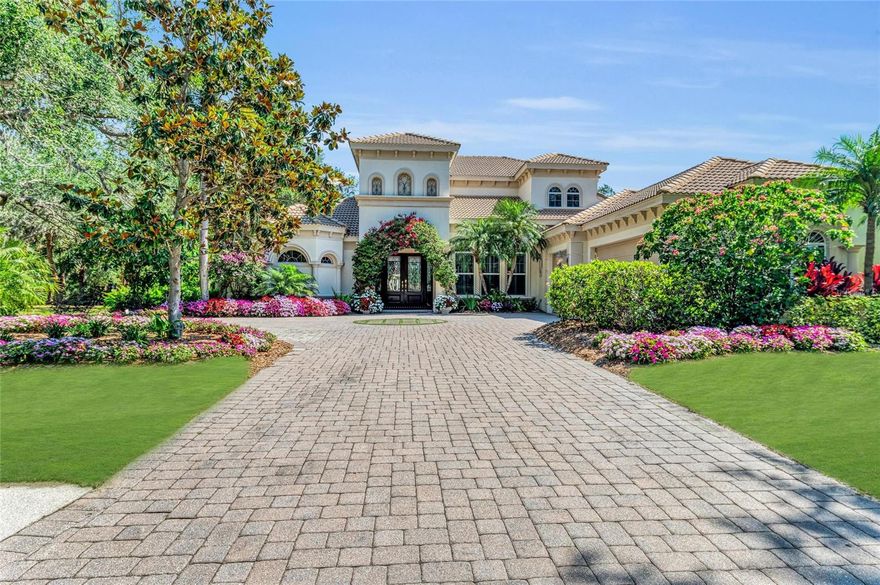 Experience the pinnacle of refined Florida living in this exquisite residence in University Park Country Club. Poised on an expansive corner lot embraced by majestic oak and jacaranda trees, this home is a masterpiece in elegance and sophistication. Every detail has been meticulously curated, from the bespoke wood-paneled ceilings and handcrafted stone fireplaces to the rich built-in cabinetry that elevates every space. The chef’s kitchen is a work of art, featuring a professional-grade six-burner gas cooktop, sleek stainless steel appliances and stunning custom-designed counters. An adjacent bar area with a built-in wine refrigerator adds a touch of indulgence, ideal for entertaining in style. Each generously sized bedroom offers a private en-suite bath and impressive closet space, ensuring comfort and privacy throughout. A grand bonus room with its balcony provides flexibility to serve as a fifth bedroom, game room or executive office. Go outside to your private resort, complete with a sparkling pool and spa, a cozy outdoor fireplace and a full gourmet summer kitchen. The property also features fully owned solar panels, dramatically reducing energy costs without compromising on luxury. Residents of University Park Country Club enjoy access to world-class amenities including championship golf and tennis facilities, state-of-the-art fitness centers, swimming pools and fine dining. Ideally minutes from the UTC Mall, award-winning beaches, upscale dining and premier medical facilities in Lakewood Ranch, Bradenton and Sarasota. This extraordinary home must be seen to be fully appreciated.