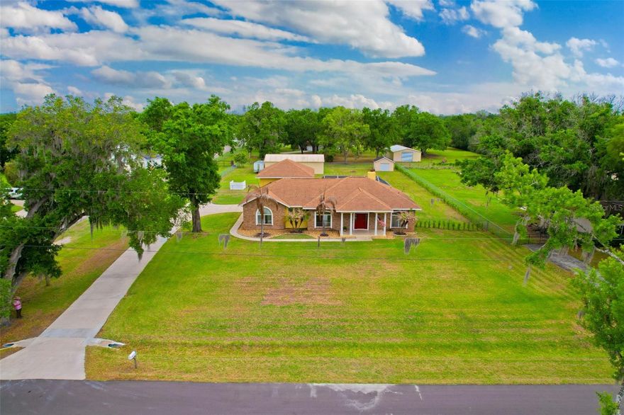 4 BEDROOMS, POOL, 1500 + SQ FT WORKSHOP, 1+ ACRE, NO CDD FEES, NO WATER BILL, AND REDUCED BY $45,000 FROM THE PREVIOUS LISTING
Tucked beneath open skies and surrounded by room to roam, this one-of-a-kind custom-built home invites you to slow down and enjoy the lifestyle you’ve been dreaming of. A welcoming front porch sets the tone, perfect for morning coffee while taking in the quiet countryside.
Inside, the home opens to a spacious great room filled with natural light, soaring 10–12 ft ceilings, and a cozy wood-burning fireplace—ideal for gathering with family or unwinding after a long day. The layout offers both comfort and flexibility, with three bedrooms and two bathrooms on the main floor, plus a large upstairs bonus room (Could be used as a bedroom) or loft - perfect for a game room, home office, or guest retreat.
The open-concept kitchen is designed for both comfort and connection, featuring a spacious breakfast bar, stainless steel appliances, and a seamless flow into the dining and living areas—perfect for everything from casual mornings to holiday gatherings. Highlights include tall cabinetry, additional bar seating, a deep walk-in pantry and a double-basin sink with reverse osmosis water filter.
The generously sized primary suite serves as a private retreat, featuring a spa-like bathroom with a jetted garden tub, separate shower, and a spacious walk-in closet. The two secondary bedrooms are located in a separate wing of the home, offering privacy and comfort—one even includes a deep walk-in closet for extra storage.
The backyard is designed for enjoying the Florida outdoors, featuring a screened pool with color-changing lighting, expansive decking, and a newly added paver patio with a firepit—perfect for evenings under the stars.  The fully fenced yard is perfect for pets to roam and enjoy and a privacy hedge was just planted.
Step outside and embrace true country living with plenty of room for all your toys, hobbies, and gatherings. In addition to the attached side-entry 2-car garage—spacious enough for a full-size trucK. Complete with two roll-up doors, a separate single-door entry, epoxy flooring, its own electrical panel, and a utility sink with running water, this space is built to impress. The 1500+  sq ft workshop FEATURES two industrial fans, along with work tables and cabinets, conveying to the buyer, making it ideal for car enthusiasts, hobbyists, or anyone needing a versatile workspace for a small business.
It also has a 12x16 detached shed with a roll-up door on a concrete slab, which provides additional storage for lawn equipment and tools. The extended driveway offers ample parking for multiple vehicles, guests, boats, or RVs.
RECENT UPDATES include a new roof (2021), fresh exterior paint (2021), updated front porch tile (2021), an A/C unit upstairs (2022), and a new well (2023), giving you peace of mind and added value. Plus, NO flood insurance is required, and the septic and fireplace have been recently inspected. Other things that you may not know about is septic was cleaned/inspected in 2022, the pool is 6 ' deep,220 amp in the shop, and av monthly power is approximately 300/yearly
If you’ve been searching for space, privacy, and the freedom to live your way, this is the perfect place to call home. Schedule your private showing today and experience the charm of country living for yourself.