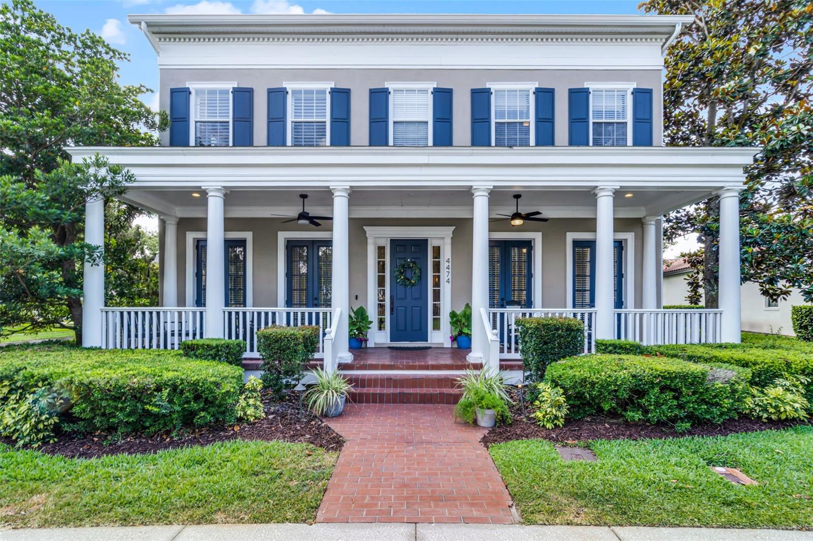 A truly rare find in Baldwin Park, this architecturally distinguished Colonial Revival-style home with Georgian influences blends timeless elegance with thoughtful modern design. Situated on a corner lot directly across from Enders Park, this home offers front-row access to the playground, pool, and gym. The stately façade, with classic shutters, a column-lined front porch, and professionally landscaped grounds, sets the tone for what lies inside. Elegant architectural details, including rich wood flooring, crown molding, plantation shutters, and designer lighting, carry throughout the home. Inside, a welcoming formal living room greets you at the entry and flows into a dramatic formal dining room adorned with a sparkling chandelier. A dedicated home office with French doors offers a peaceful work-from-home setting with views of the front porch. The open-concept family room, anchored by a stunning stacked stone fireplace, connects seamlessly to the adjacent chef’s kitchen, where you'll find crisp white cabinetry, quartz countertops, stainless steel appliances, under-cabinet lighting, and an oversized center island with detailed millwork. The casual dining area offers additional built-in cabinetry, providing excellent storage and function. Located on the first floor, the spacious primary suite is a relaxing retreat with a double-sided fireplace that enhances both the bedroom and the luxurious en-suite bath. French doors open directly to the pool area, making it easy to step outside and unwind. The bathroom features a double sink vanity, a jetted garden tub, a steam shower, and a sizable walk-in closet. Before heading upstairs, you'll also find a charming wine cellar beneath the staircase, a mud room, and a separate laundry room—both featuring built-in cabinetry and excellent organizational space. Upstairs, a spacious loft provides a versatile second living area, surrounded by four secondary bedrooms with charming architectural details and two remodeled bathrooms. The standout feature on this level is the custom-designed home theater, complete with tiered leather seating, surround sound, and dramatic millwork for a true cinema experience at home. Step outside into your private courtyard oasis, where a solar-heated pool and spa sit surrounded by privacy walls and low-maintenance artificial turf. A brick-paved lanai offers plenty of space to relax, dine, or entertain with ceiling fans and elegant French doors that open into multiple interior rooms. Tucked at the rear of the property, the 4-car garage features epoxy floors, overhead storage, and ample space for cars, golf carts, or recreational gear. Above the garage is a fully remodeled, private 2-bedroom, 1-bath apartment, complete with its own full kitchen, living area, and laundry. This flexible space is ideal for multigenerational living, long-term guests, or income potential—a rare and valuable feature in the community. Additional updates include a new roof (2019) and three A/C units replaced between 2018 and 2022. All of this is located in the heart of Baldwin Park, one of Orlando’s most sought-after communities known for its pedestrian-friendly design, top-rated schools, lakeside trails, multiple parks, community pools, dog parks, boutique shopping, fitness studios, waterfront dining, and vibrant year-round events including concerts, farmers markets, and seasonal festivals. This is a rare opportunity to own a one-of-a-kind home with versatile modern living in an unbeatable location.
