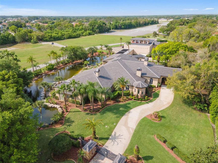 Set on 3.4 acres of beautiful grounds with interconnected flowing ponds, this privately gated estate is located in Spruce Creek Fly-In, the world’s most famous residential aviation community. Spanning approximately 15,000 square feet of gracious living space, featuring indoor and outdoor spaces that flow together, the spectacular property is highlighted by a resort-style swimming pool, spa, summer kitchen and an expansive terrace for lounging and alfresco dining. A home perfect for both family and entertaining, its multiple office spaces offer an ideal life-work environment. Two private on-site hangars are sized for most business jets, general aviation aircraft, many helicopters and are suitable for motor coaches, car collections, boats and many other uses. A portico entryway opens to the grand foyer. Once inside, bright social spaces lined with European marble flooring showcase an elegant floor plan designed for casual everyday living or grand gatherings. The expansive living room imparts a serene view of the terrace, pool and gardens. An open-concept circular kitchen boasts extensive countertop sitting space and an attached secondary kitchen, connected via a closable pass-through, designed for storage, prep work and cleanup. An oasis of tranquility, the owner's suite has an immense walk-in closet, impressive bath, coffee bar with refrigerator, fireplace and exercise room. French doors open to the gardens and pool deck. The office with fireplace, a home theater, wet bar, walk-in wine storage room and three en-suite bedrooms are on the primary level. The lower level has a fifth en-suite bedroom, second media room and game room. There are five fireplaces, six full baths and two half baths in the main residence, an attached three-car garage with a 50amp electric car charger and ample guest parking. Nestled between the hangars is a multipurpose retreat with private entrance, ideal for professional endeavors, in-laws, guests, personal pilots and other staff. The ground level has a reception foyer, spacious office, full bath and a large European-style sauna. The second level has two en-suite bedrooms, a lounge area, kitchenette and balconies overlooking the runway, private tennis court and gardens. Designed for multigenerational living, an elevator, as well as stairs, provide access to this level and the building’s rooftop pavilion. The two hangars are accessible from this building, providing a superb flight planning environment. Both have epoxy floors and remote-controlled bi-fold hangar doors. Smart house features abound with security system and cameras, auto-controlled LED lighting, whole-house audio, pool/pond features, remote gates and multizone air conditioning. An hour outside of Orlando, this unique property is near shopping, dining, renowned beaches, NASCAR headquarters, Daytona International Speedway, Embry-Riddle Aeronautical University and Stetson University. The 24-hour, staff-gated and golf-car friendly community is home to a private 4,000-by-175-foot paved runway with GPS approach, paved helipads and taxiways, VASI approach lights and aviation services, including 100LL and Jet A fuel. Membership to the club is optional, which offers golf, tennis, pickleball, a fitness room, pool, private restaurant and bar. There are parks, a playground, a hair salon, public restaurant and a dock on Spruce Creek waterway for fishing or launching a kayak or canoe. Room Feature: Linen Closet In Bath (Primary Bedroom).