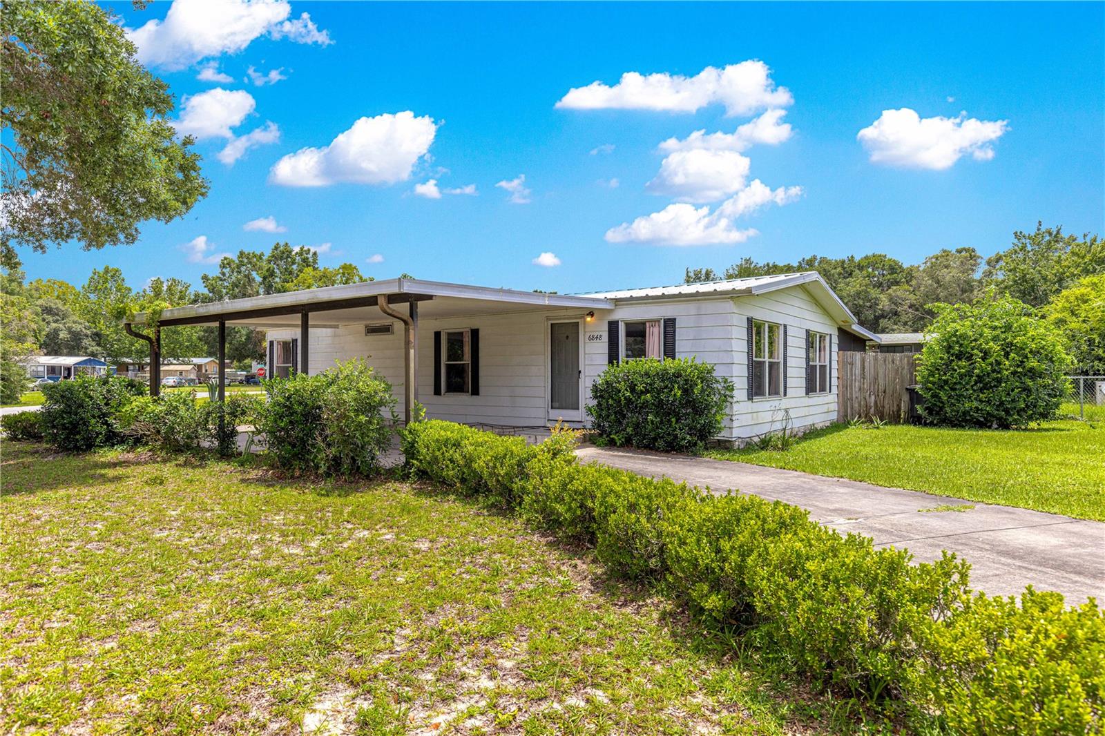 Welcome to Sun Country – No Lot Rent, No HOA! This charming 2-bedroom, 2-bath home is perfectly situated in the family-friendly Sun Country community, just off State Road 200 for unbeatable convenience to shopping, dining, entertainment, medical facilities, and quick access to I-75.Enjoy peace of mind with a new A/C system and ductwork installed in 2024, as well as a metal roof added in 2016. Inside, the home features luxury vinyl plank flooring throughout and updated bathrooms for a fresh, modern feel. The layout offers comfortable living space, a screened room perfect for relaxing, and a fenced backyard—ideal for pets or play. Additional highlights include a new washer and dryer (2024), a carport, and a convenient circle drive for extra parking.
Whether you're a first-time buyer, downsizing, or looking for a move-in-ready home in a great location, this one checks all the boxes. Schedule your showing today!
