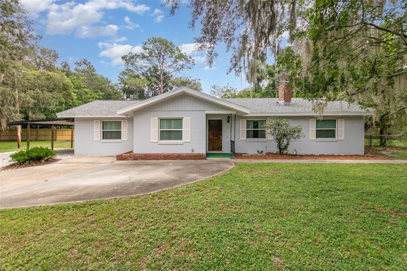 Welcome to this thoughtfully updated 3-bedroom, 2-bathroom ranch-style home that perfectly blends classic character with modern comfort. Nestled on an oversized, nearly half acre lot that has a fenced perimeter and shaded by majestic oak trees, this property offers space, privacy, and a serene outdoor setting you'll love coming home to.
Step inside to discover a fresh, modern interior featuring new flooring throughout, stainless steel appliances, and a brand-new roof for peace of mind. The spacious layout flows effortlessly, with a large screened-in room that's perfect for enjoying Florida's weather year-round—ideal for relaxing, entertaining, or dining. Outside, you'll find a fully fenced backyard with plenty of room to play, garden, or let pets roam. The circular driveway offers convenient access and plenty of parking, while the carport provides covered parking. Renter insurance required.
Located just minutes from shopping, dining, entertainment, and major roadways, this home offers both convenience and comfort.
Come see it for yourself—your next chapter starts here.